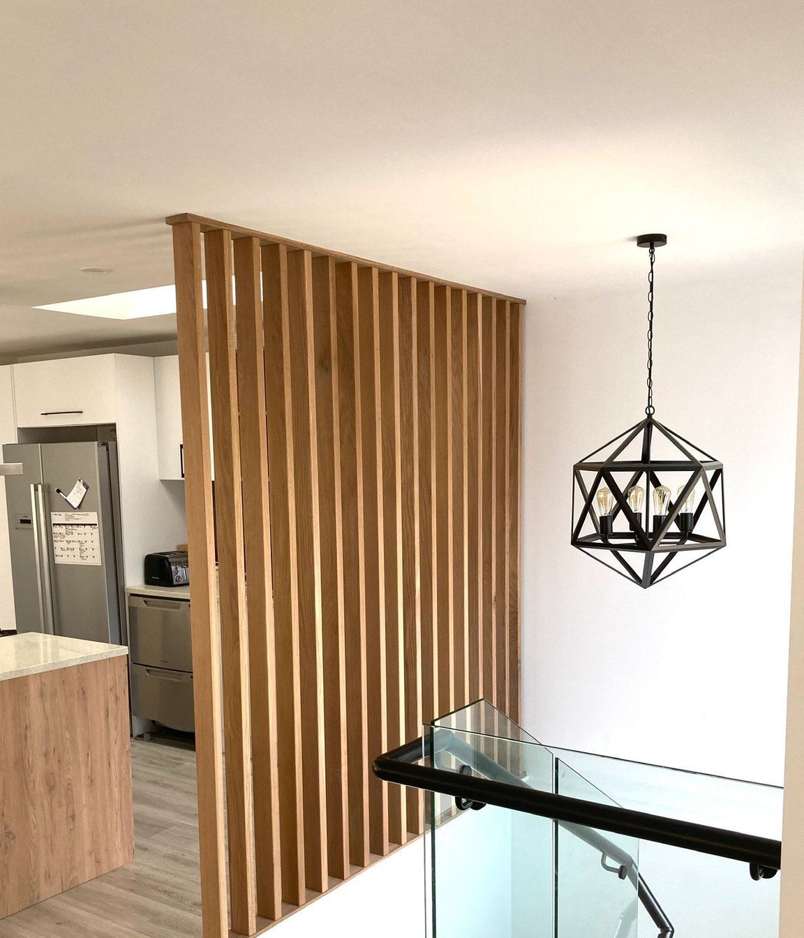 This timber feature wall creates visual separation without closing off the space.