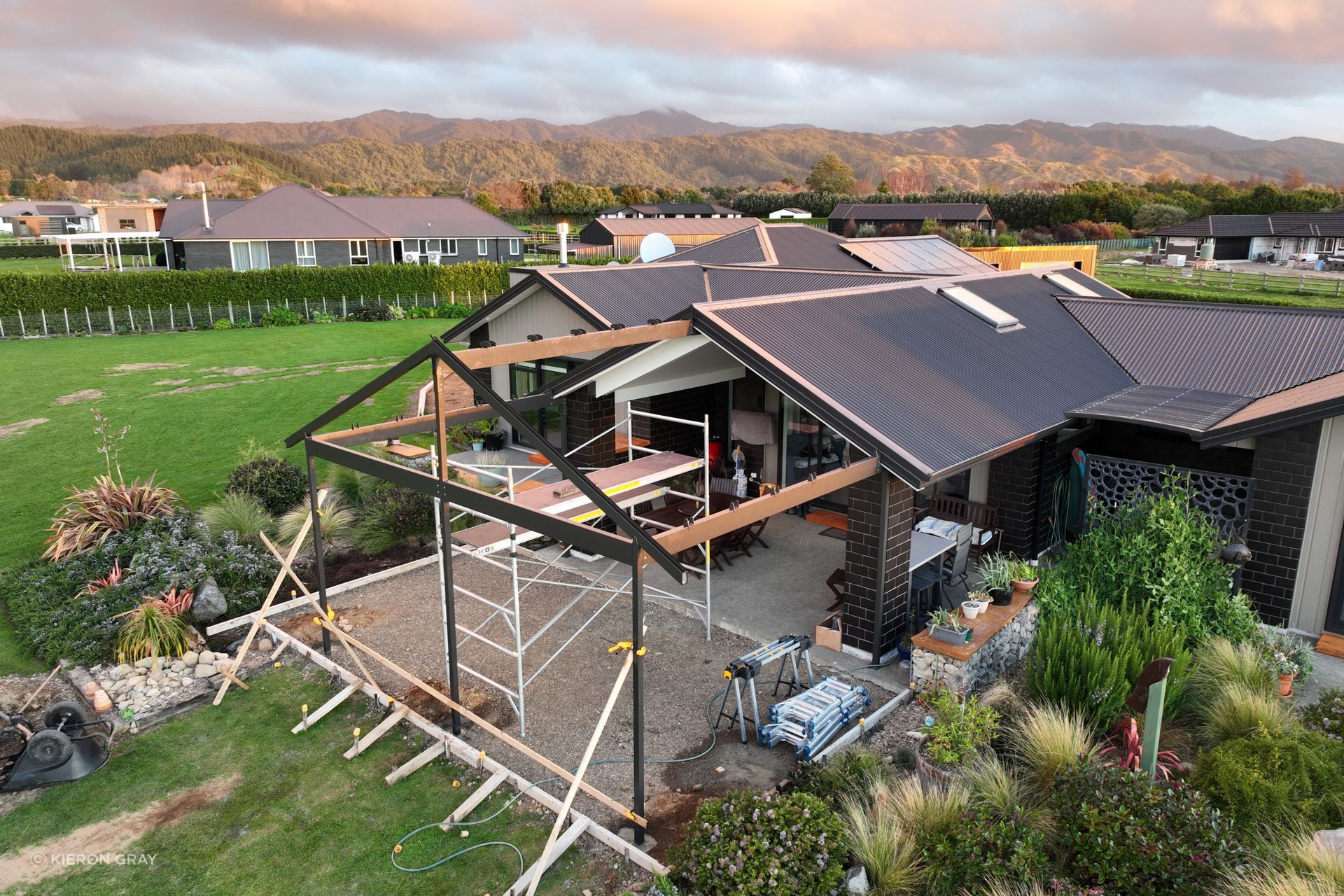 “The home has a gable roof that covers a smaller outdoor living space; as the clients wanted to extend that living area, they were looking for a gable canopy that would flow with the existing roof line.”