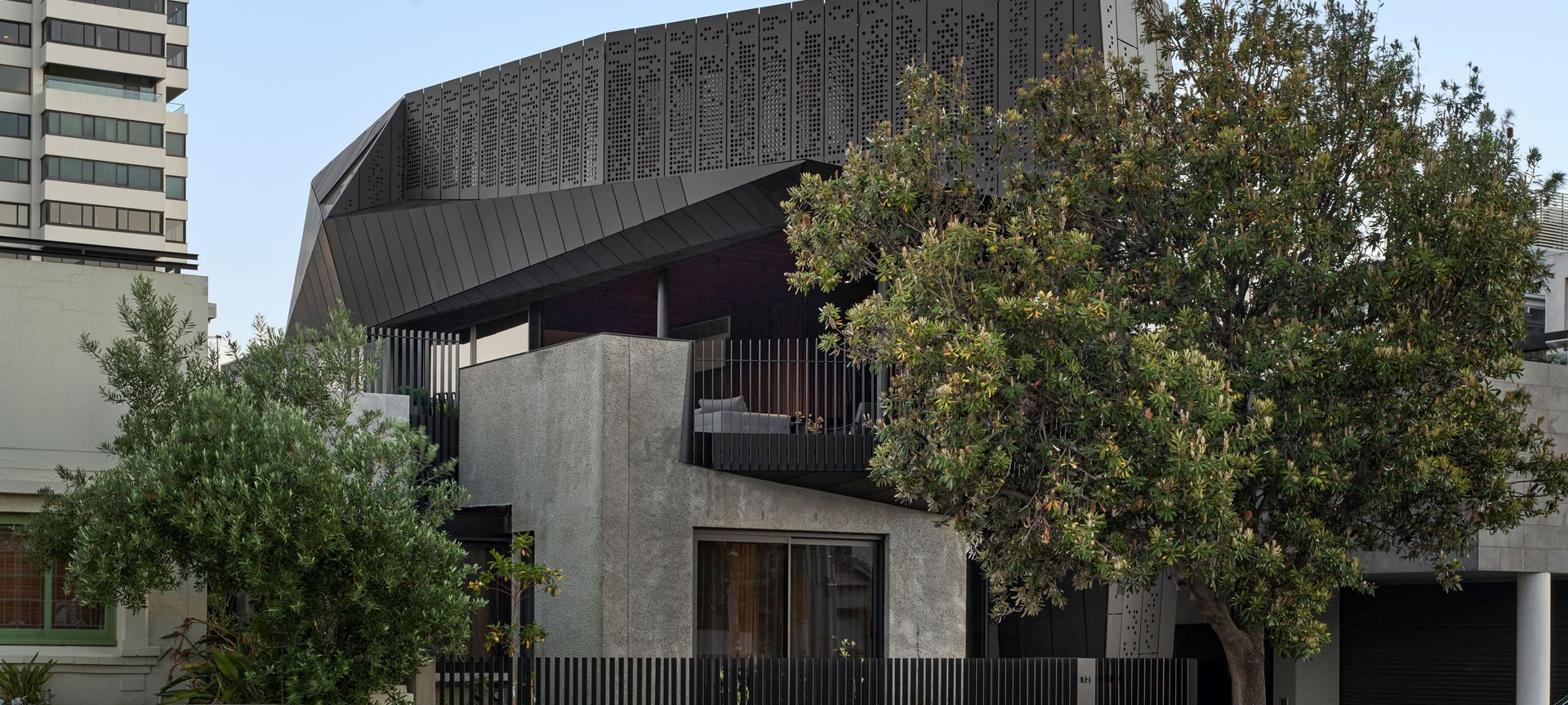 On the upper level of 'Harold' house, the custom motorised perforated aluminium screens by Shade Factor provide privacy and sun shade for the residents. Image credit: Peter Clarke.