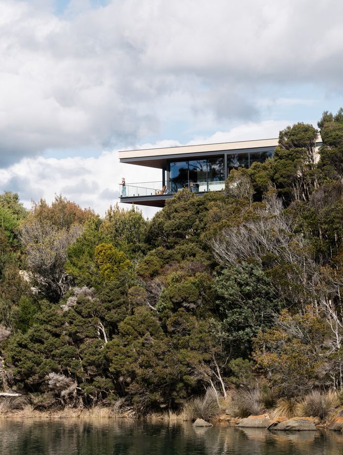 Perched above the estuary, the home maximises its connection with the surrounding nature with extensive glazing.
