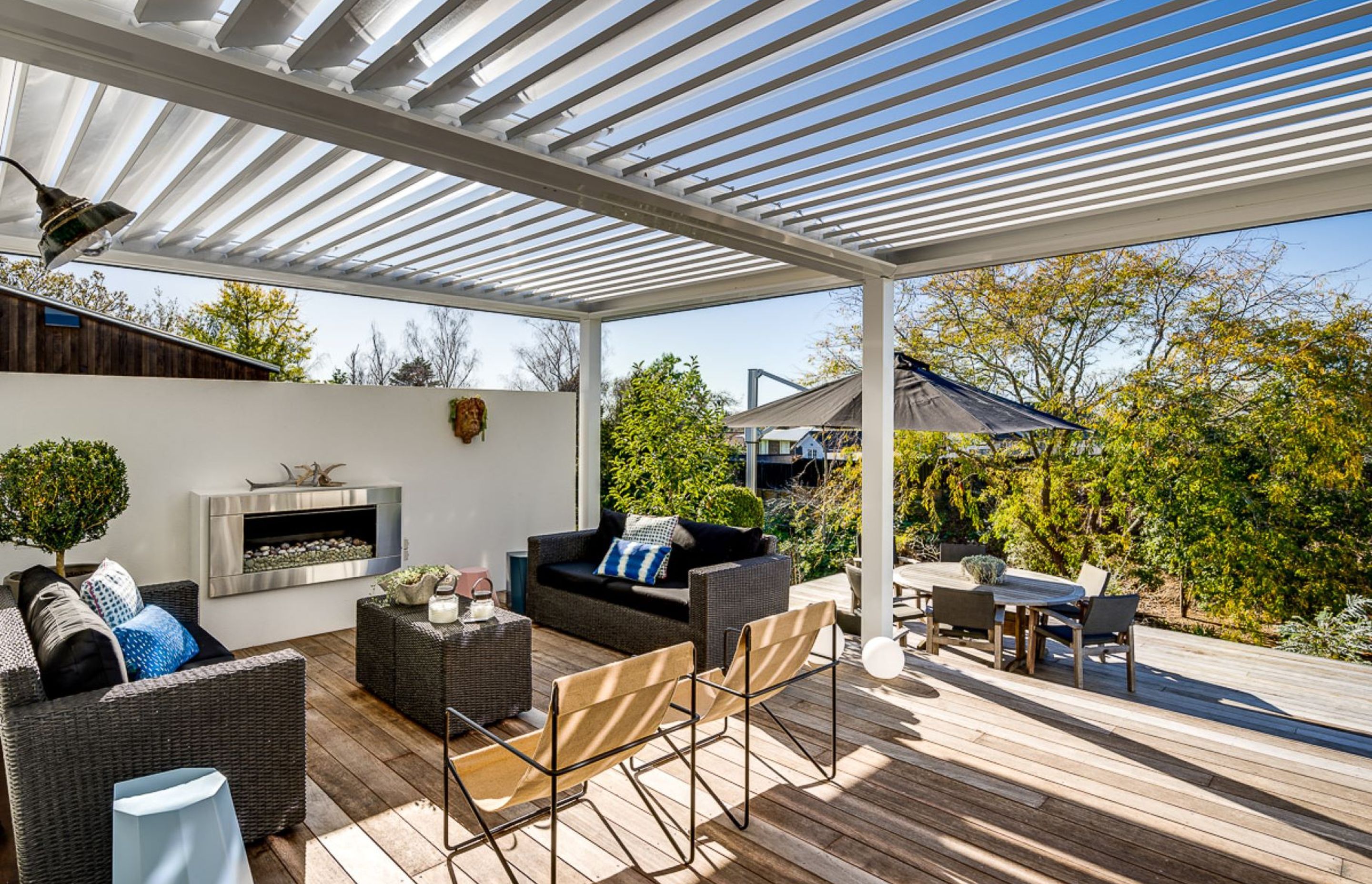 This cosy outdoor area with fireplace is enhanced with a louvre system that allows light in when it's sunny and provides protection from the rain when the louvres are closed.
