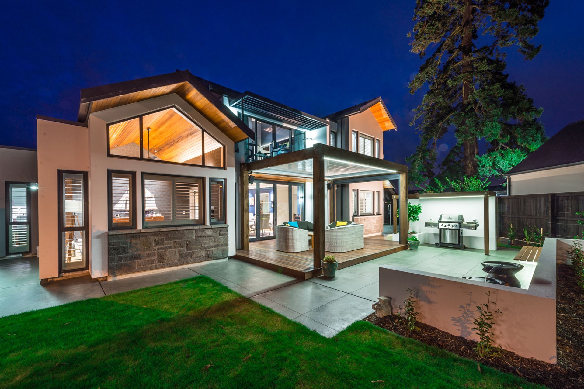 Stylish lighting frames the outdoor shelter in this Waitikiri home