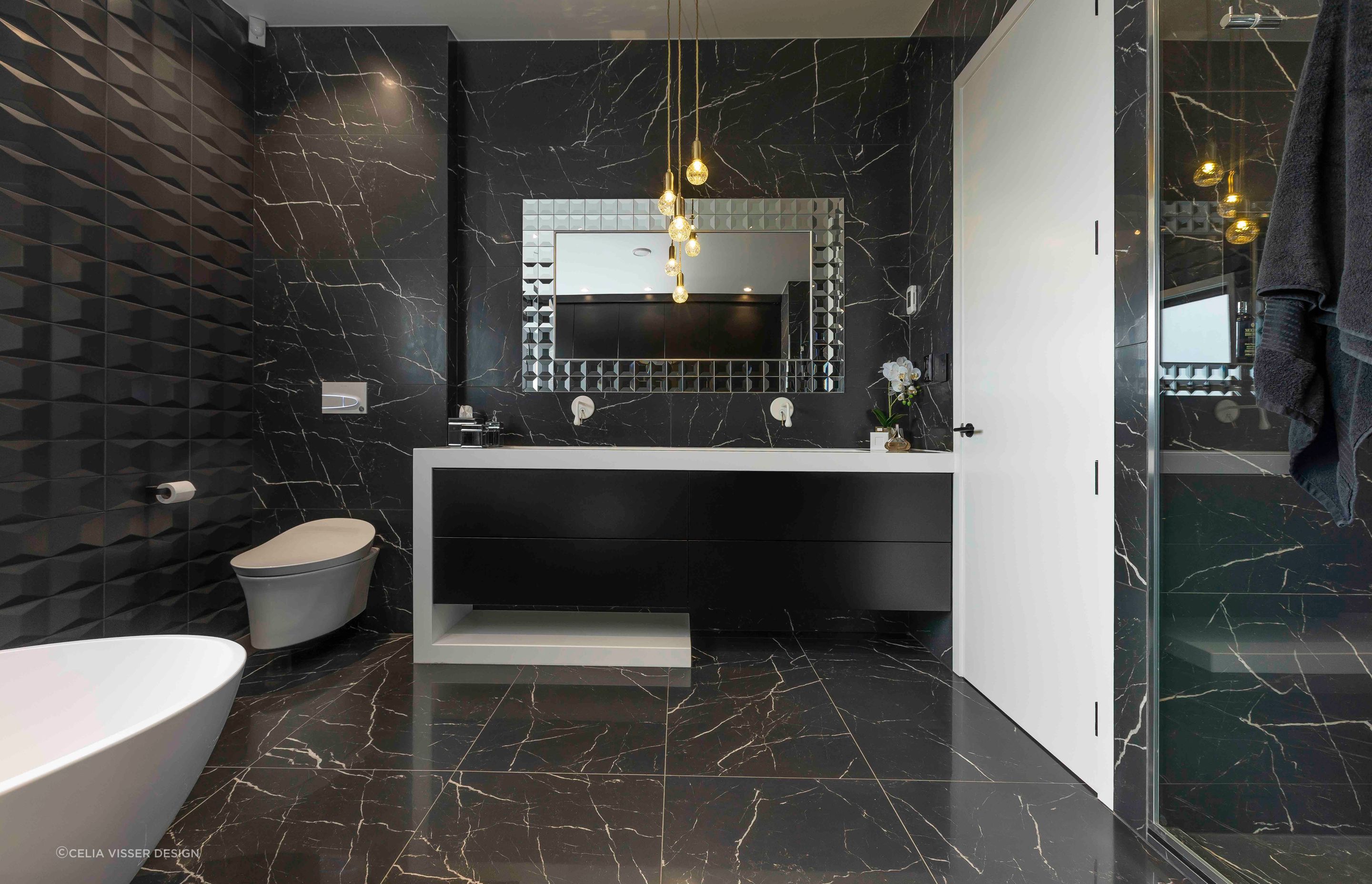 This master ensuite in Wiri shows you exactly how to use a multi-bulb fixture above a vanity