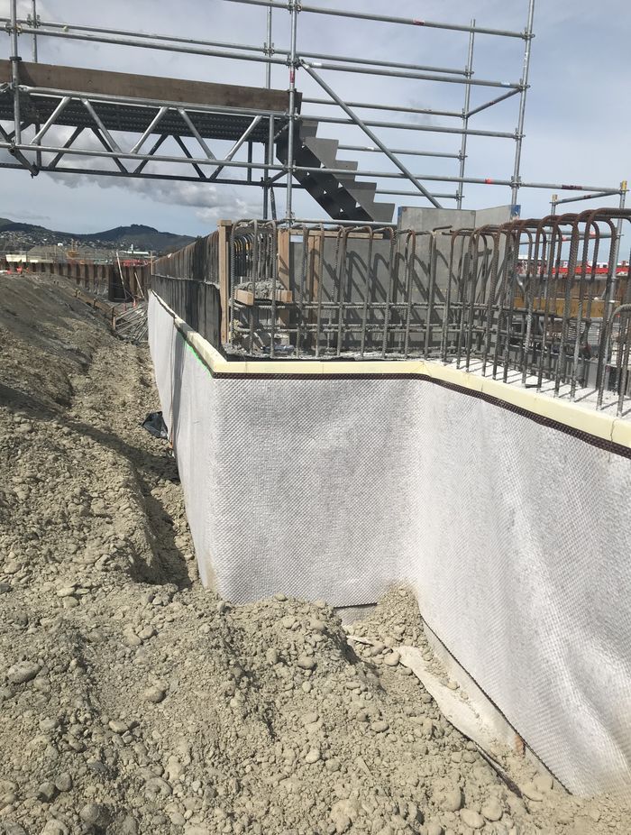 Vertical underground tanking and thermal insulation protected by a drainage and protection mat.