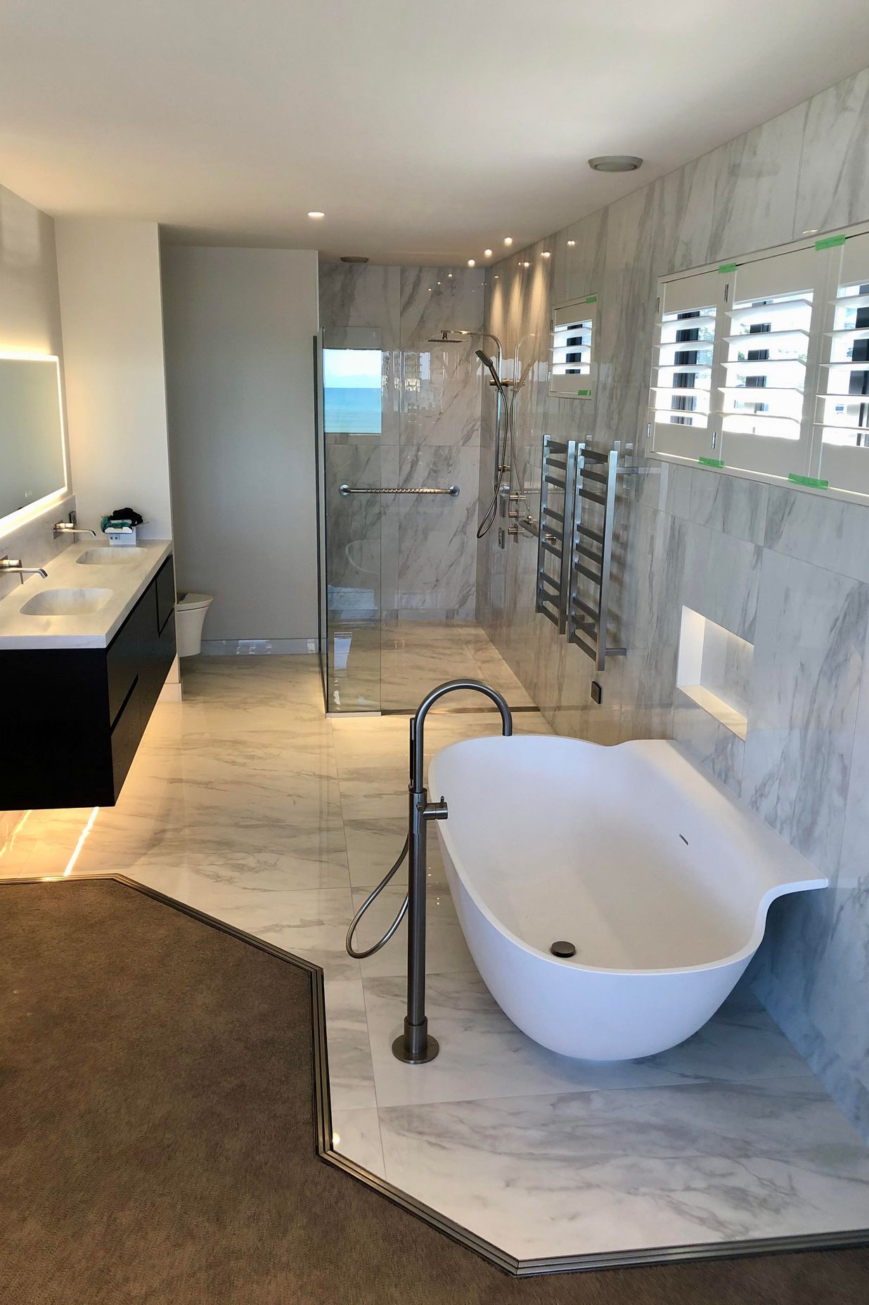 A Door Channel protects water leakage in this open-plan bathroom from going into the carpet.