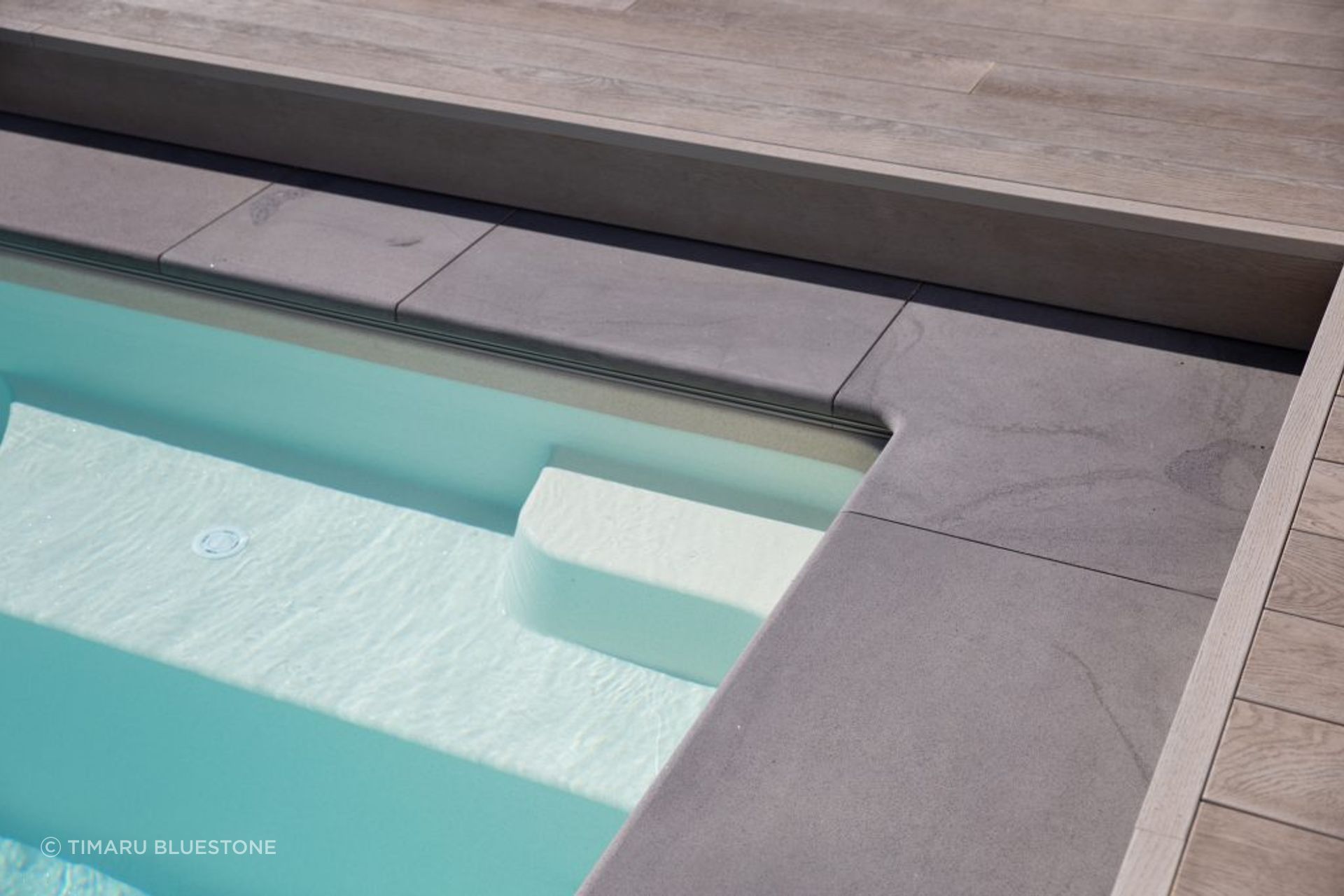 Bluestone Pool Coping adds an elegant touch, gently contrasting with the timber decking.