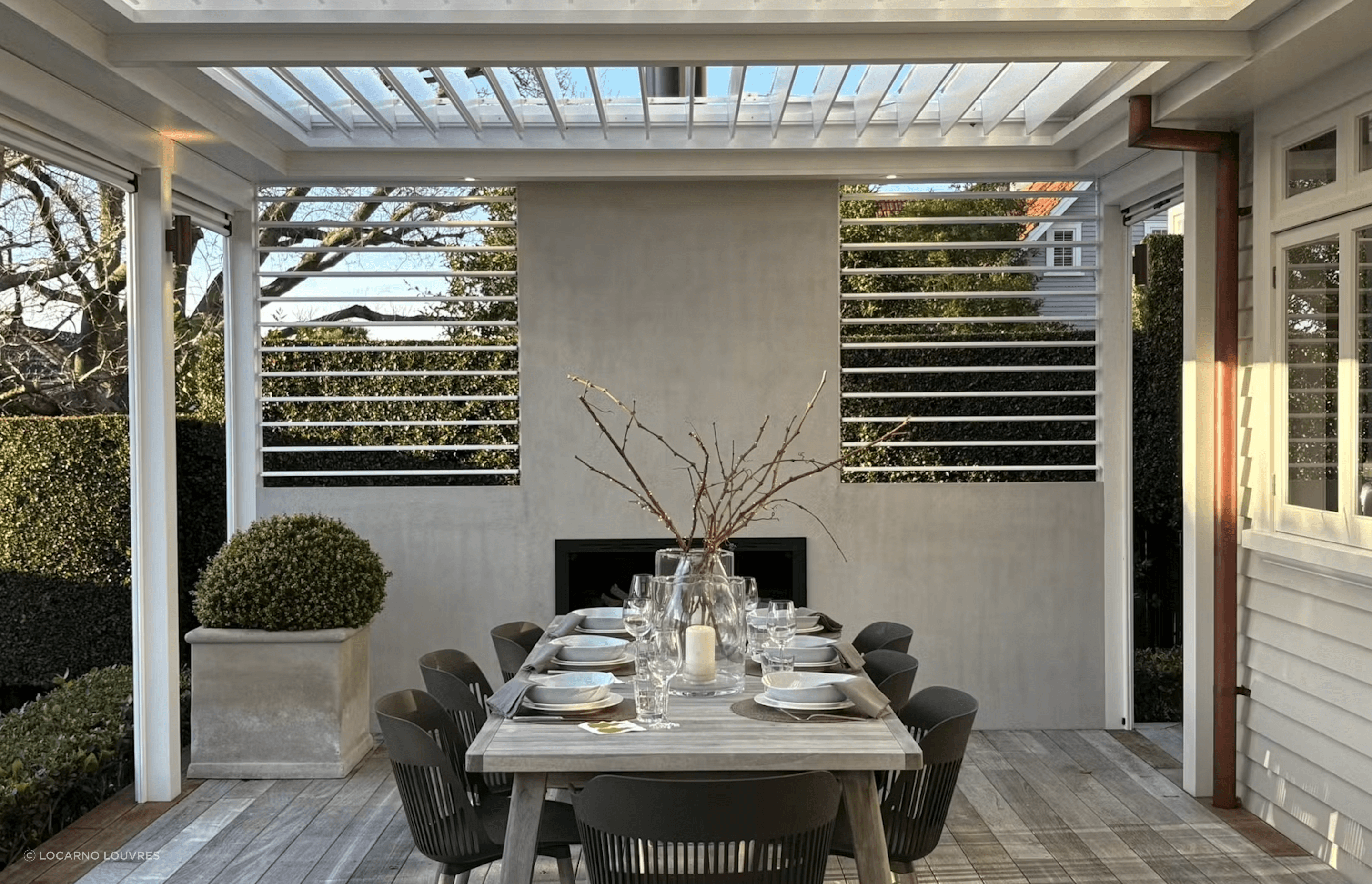 The pergola incorporates four motorised panels of The super fine profile RLS200 louvres can be closed to provide shelter or opened to maximise light in the adjacent kitchen/living rooms. Two panels of manually adjustable RL130 screens add the finishing touch on either side of the plastered chimney.