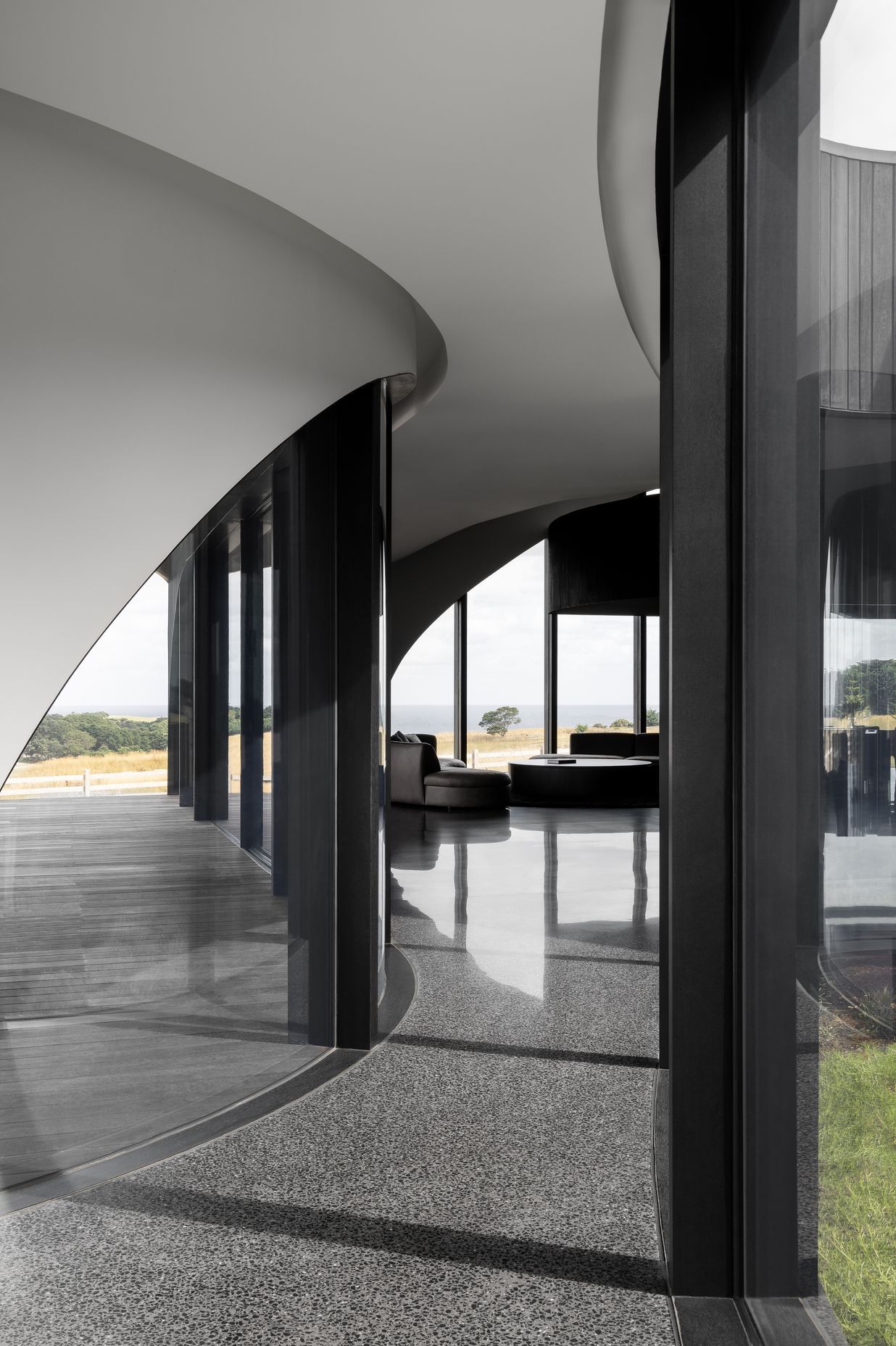 Custom curved windows mirror the rolling landscape at Peninsula House.
