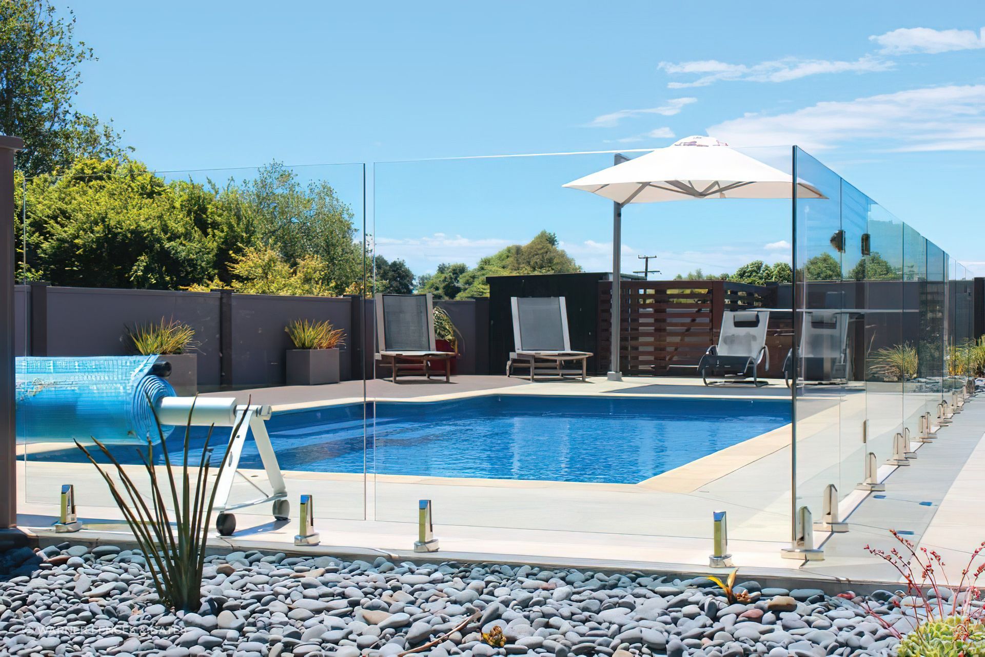 A great example of a frameless glass pool fence by Warner Fences &amp; Gates with spigots fixed to the surface.