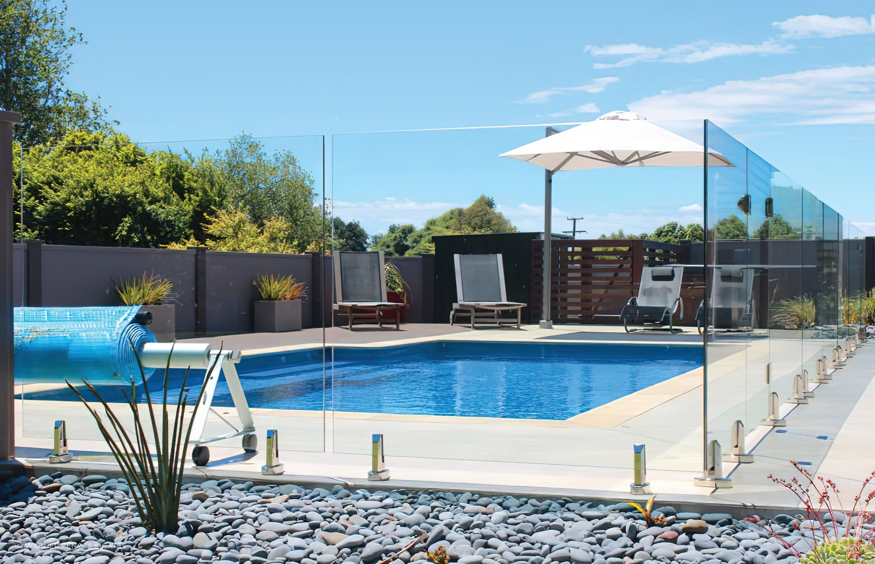 A great example of a frameless glass pool fence by Warner Fences & Gates with spigots fixed to the surface.