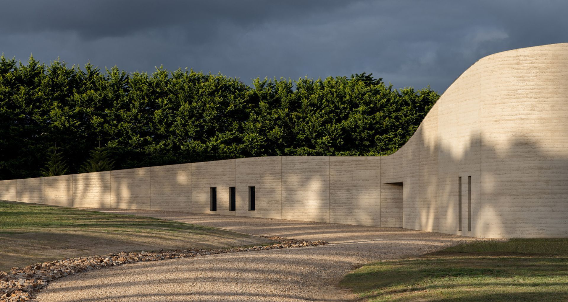 Peninsula House by Wood Marsh uses layered rammed earth as its palette, grounding the home in warm, natural tones that define this emerging Australian aesthetic | Photography by Timothy Kaye