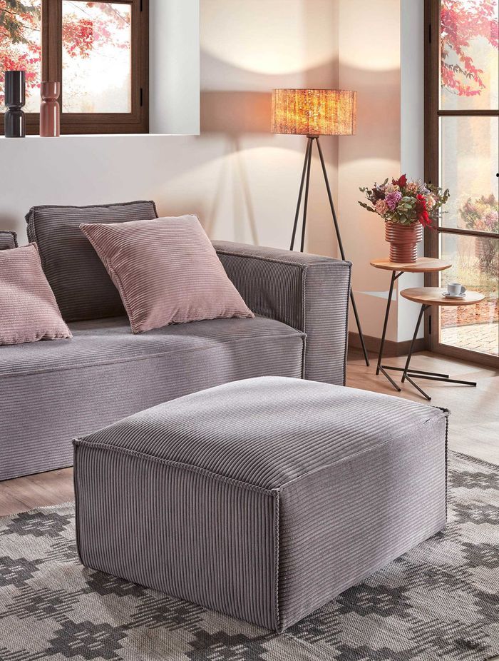 Pretty in pink: Bright pink pillows add warmth to this Kave Home grey sofa.