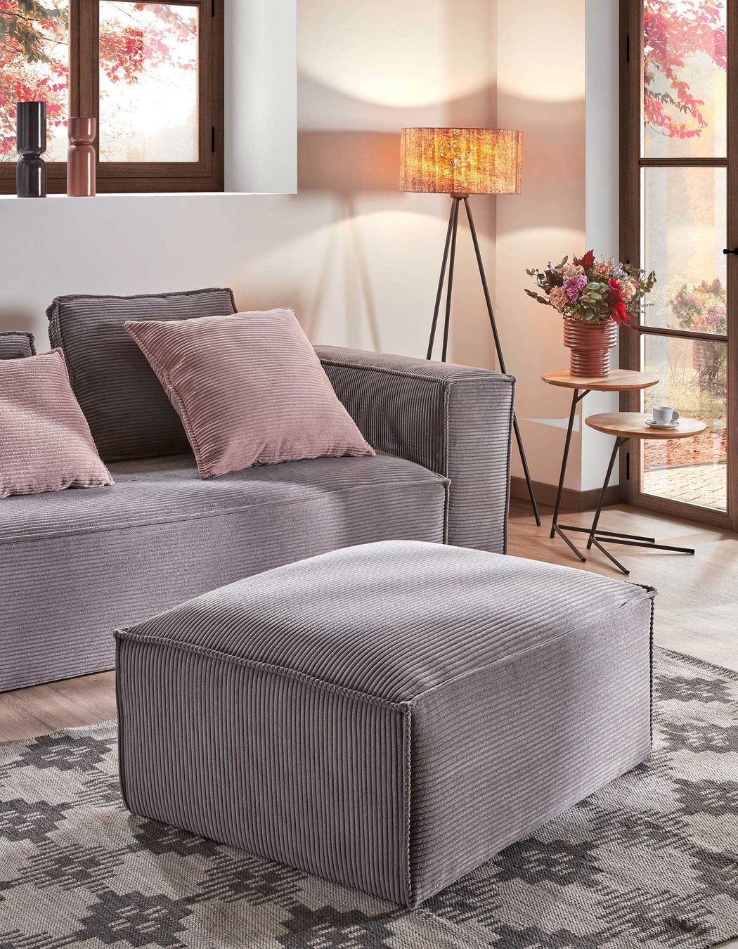 Pretty in pink: Bright pink pillows add warmth to this Kave Home grey sofa.