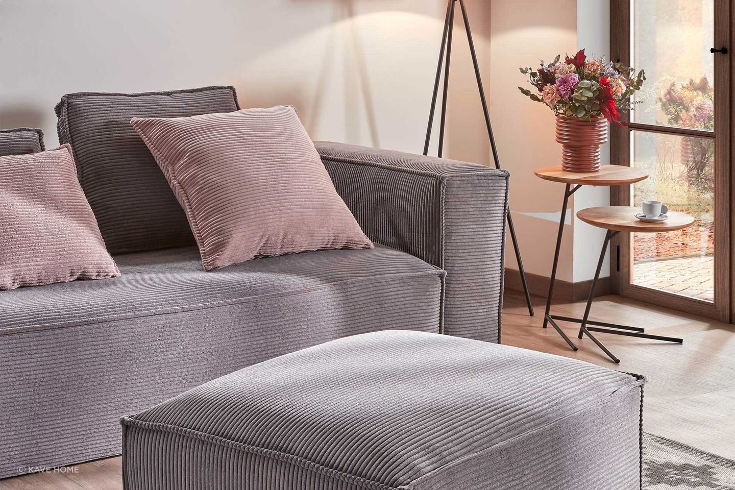 Pretty in pink: Bright pink pillows add warmth to this Kave Home grey sofa.