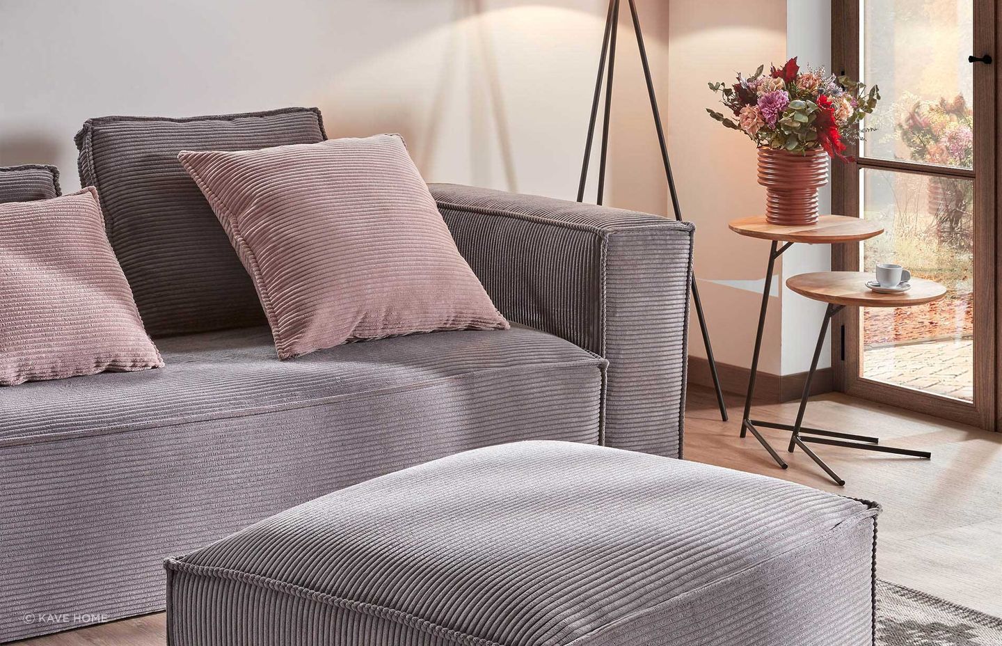 Pretty in pink: Bright pink pillows add warmth to this Kave Home grey sofa.