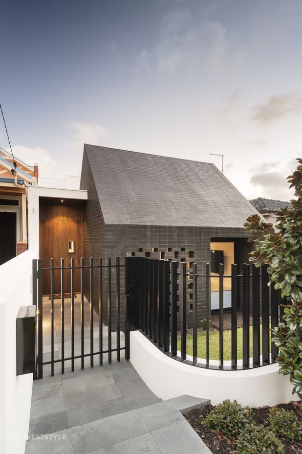 This home's side entrance is marked by a striking door that offers both privacy and intrigue. Featured project: Alma by Weststyle
