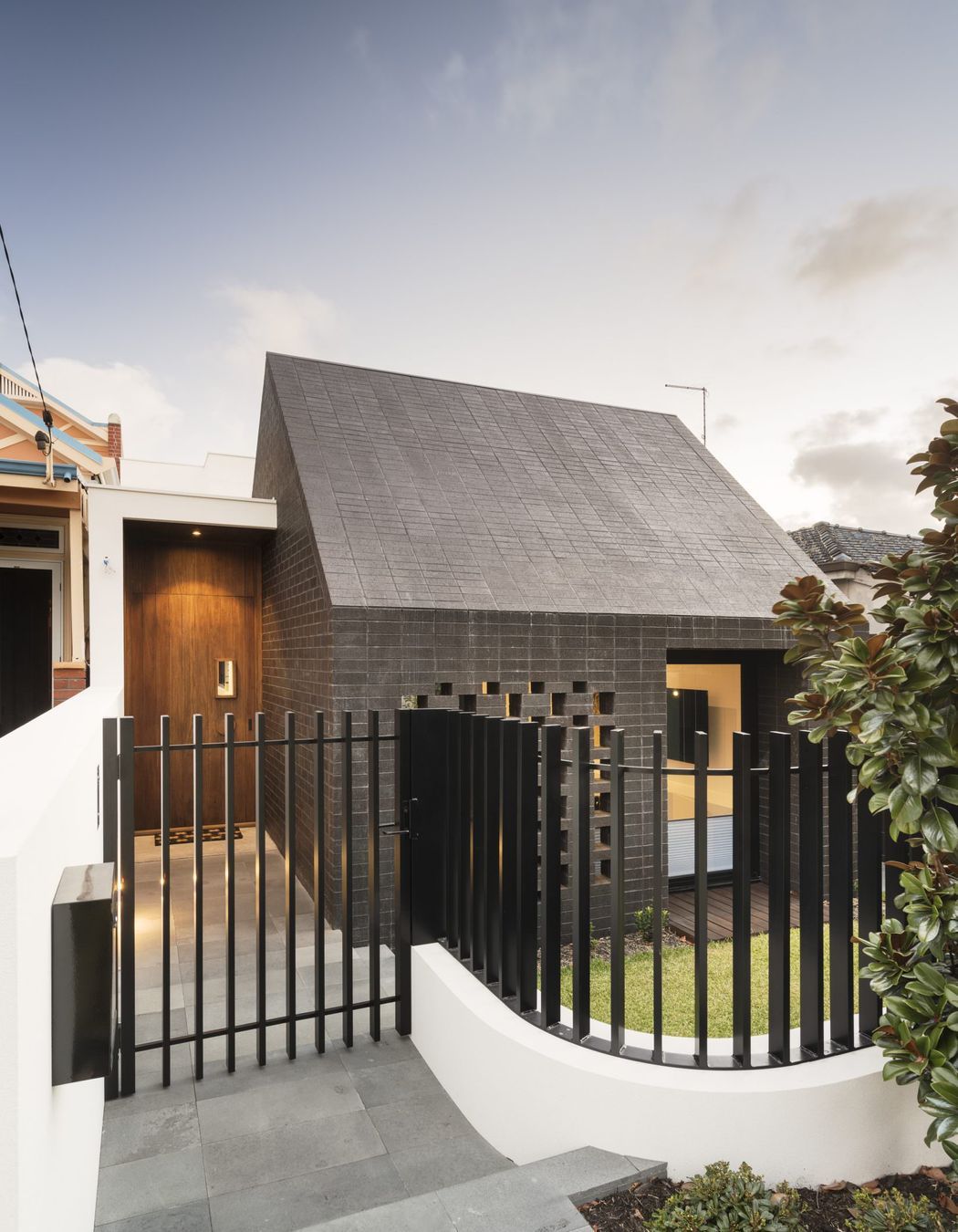 This home's side entrance is marked by a striking door that offers both privacy and intrigue. Featured project: Alma by Weststyle