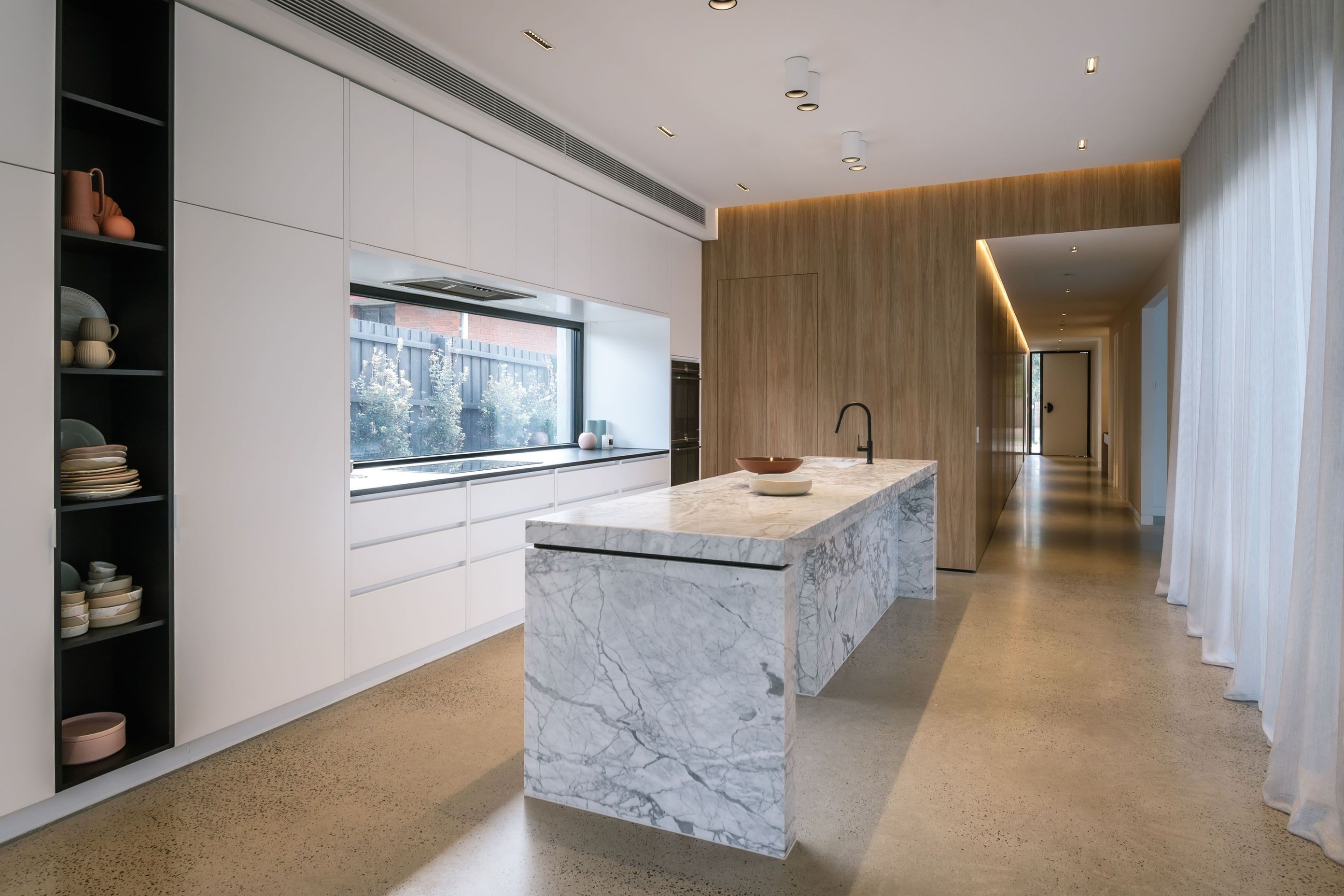 Sleek, integrated cabinets offer crisp lines and seamless aesthetics in this kitchen in Bonbeach. | Photography: Janis House Photography