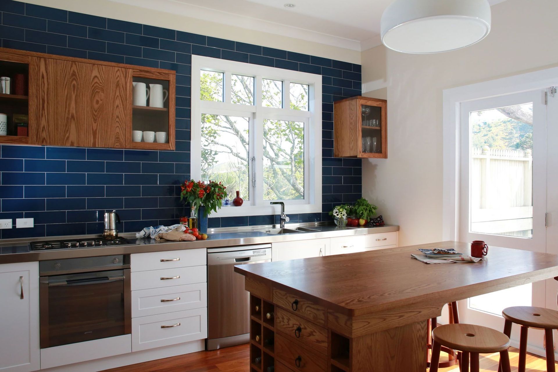 Arch handles, like those featured in this villa renovation in Wellington, add an air of elegance to the kitchen design.