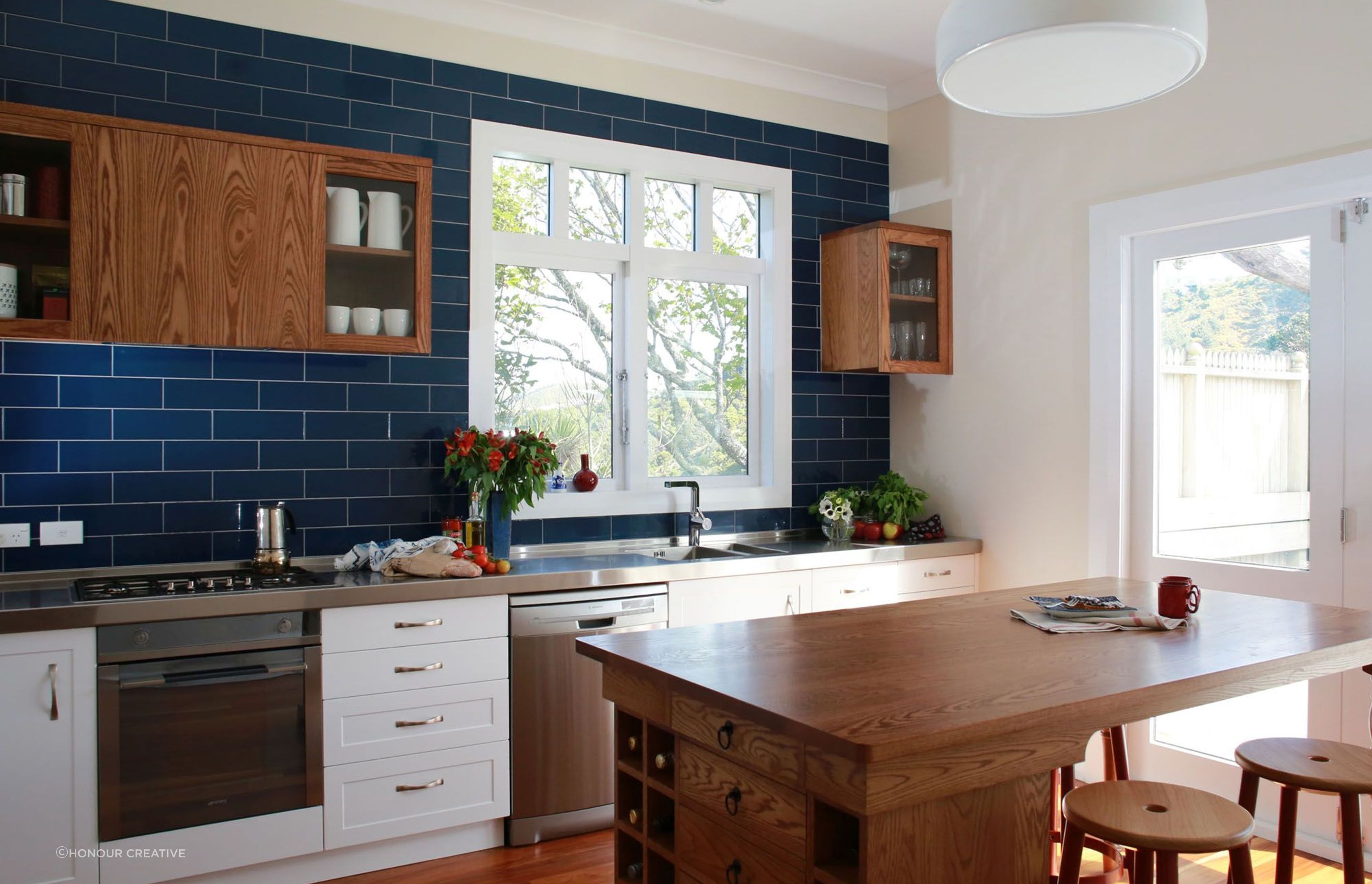 Arch handles, like those featured in this villa renovation in Wellington, add an air of elegance to the kitchen design.