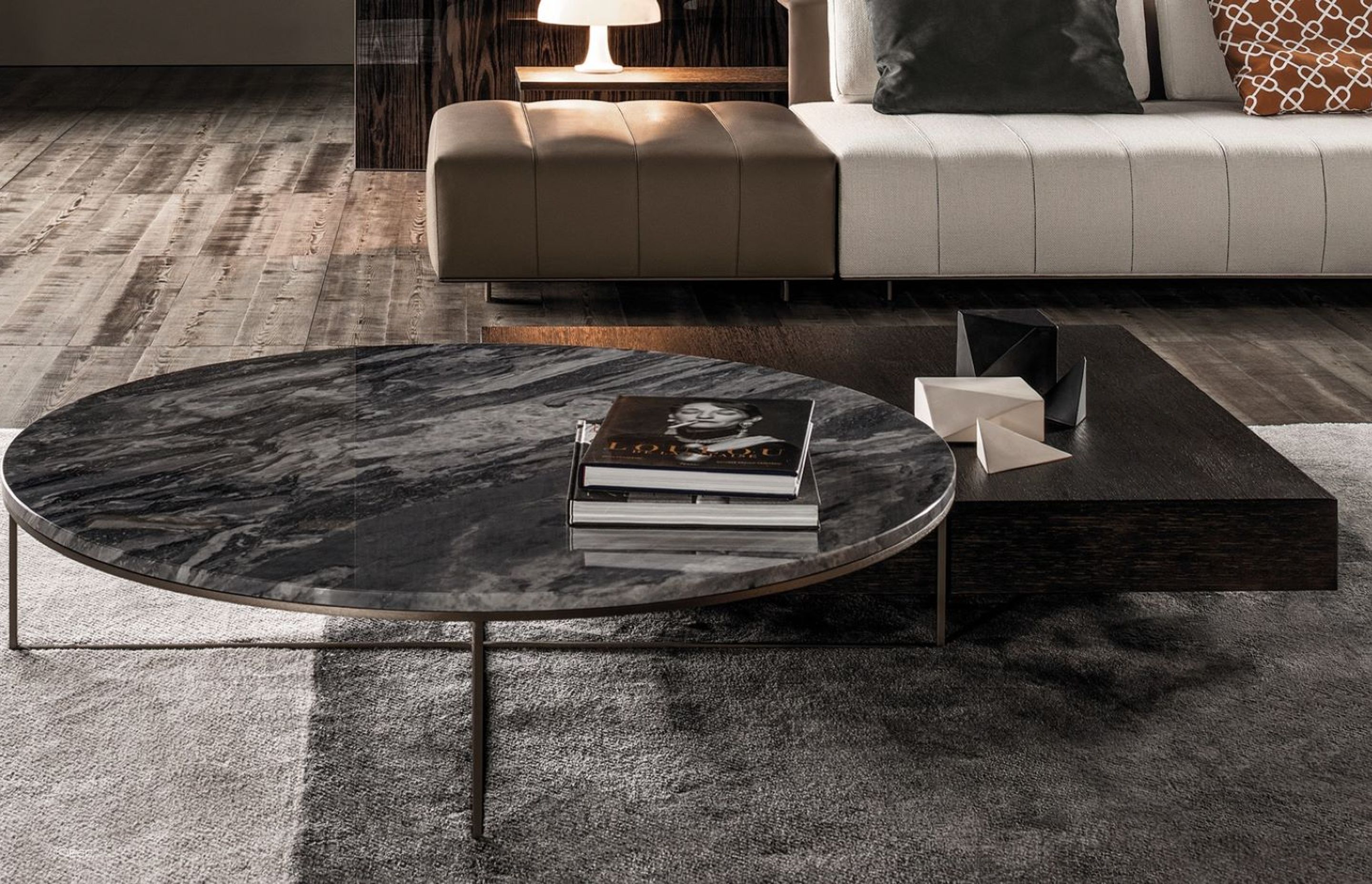 The sublime marble finish of this Calder Bronze Coffee Table by Minotti creates a striking contrast with the soft floor rug beneath it.