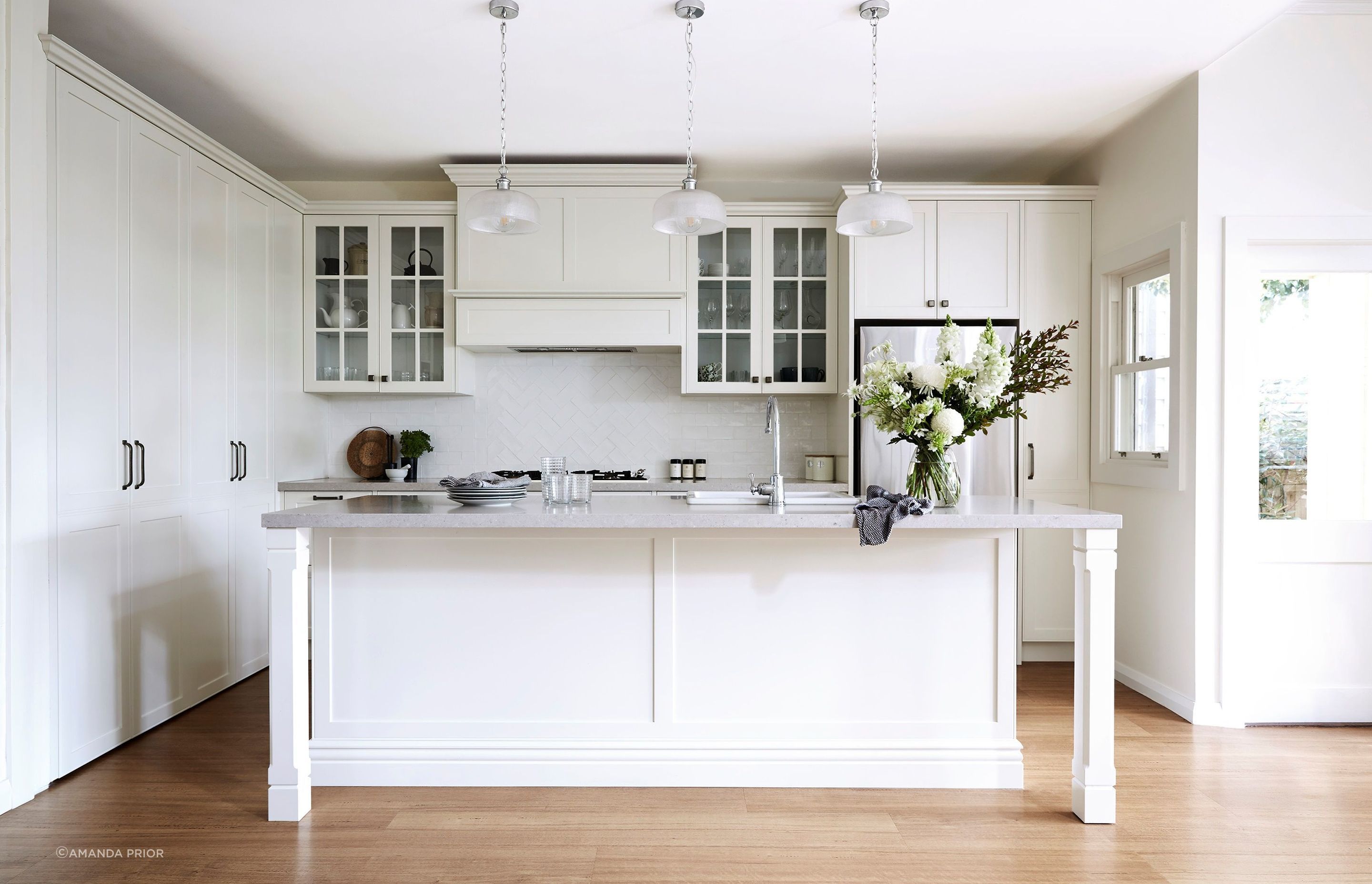 The glass front cabinets in this beautiful Seaforth Project kitchen add to the openness and elegance of the space. | Photography: Amanda Prior