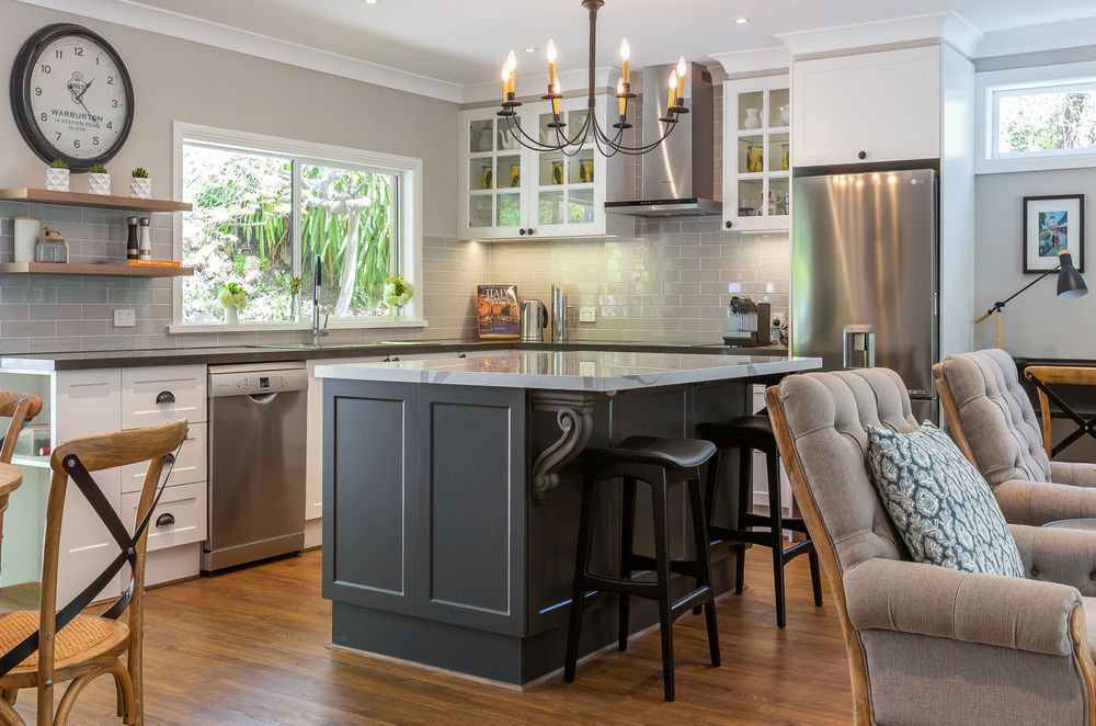 A Hamptons Style kitchen with a graceful iron chandelier.