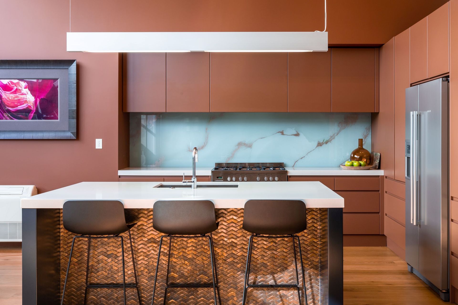 A great execution of colour featuring a blue splashback with copper marbling.