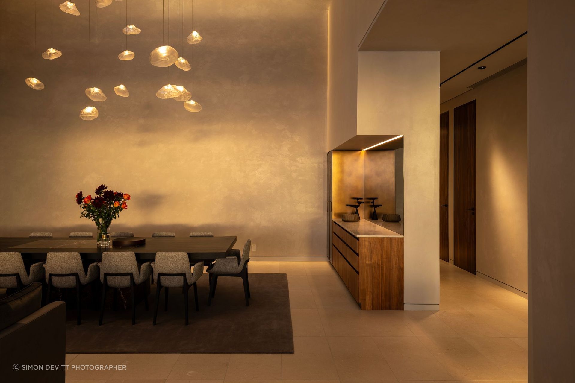 Designed for both entertaining and retreat, the home uses generous volume, warm light and a restrained material palette to make a substantial brief feel calm and composed.