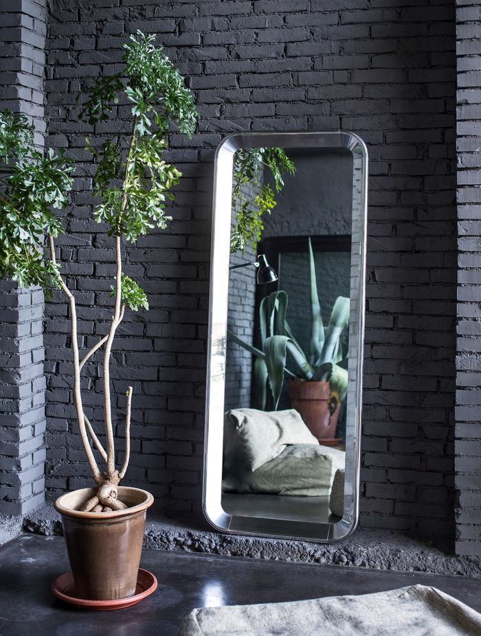 The Deja-vu Mirror by Magis, resting in the corner of a stylish space.