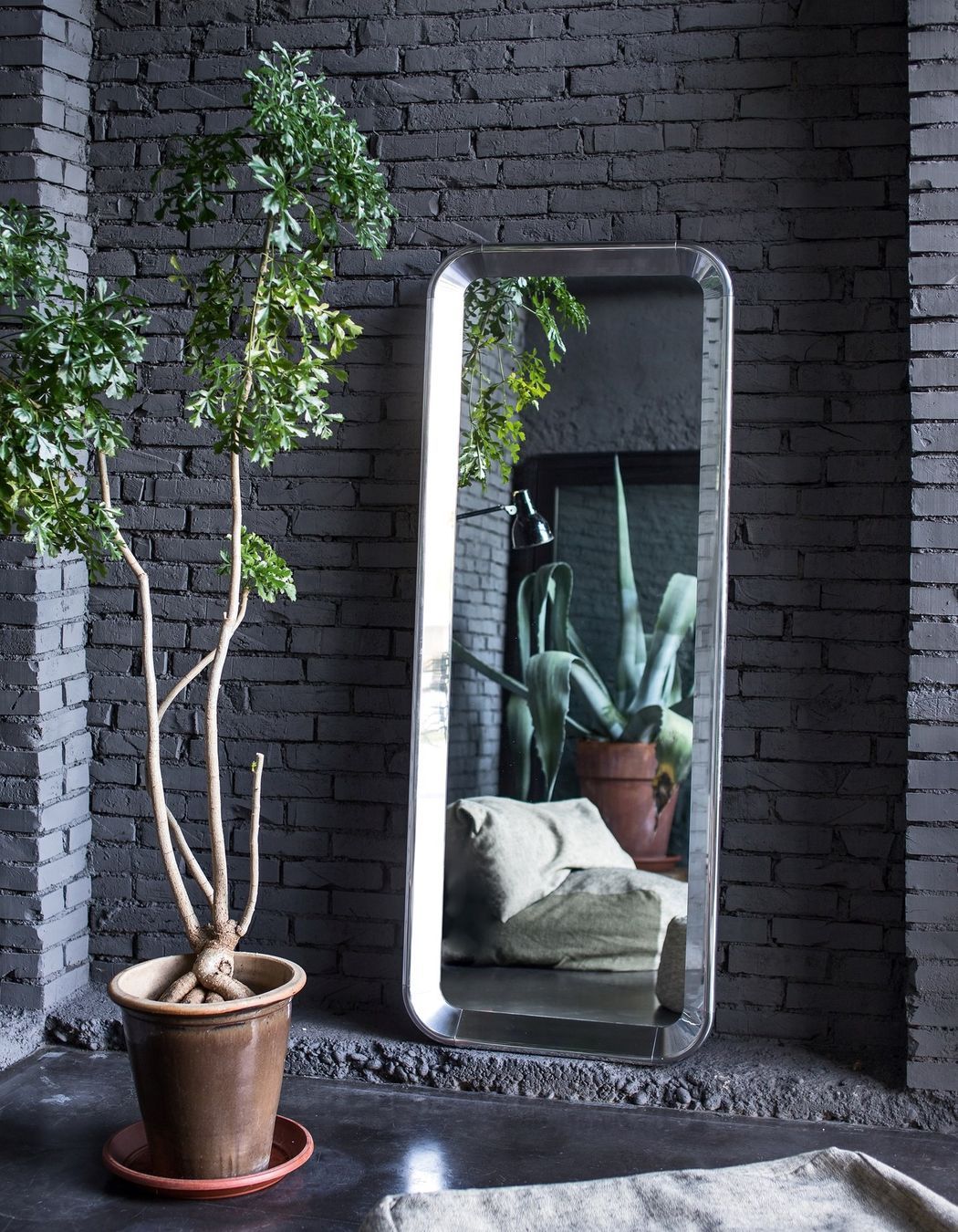 The Deja-vu Mirror by Magis, resting in the corner of a stylish space.