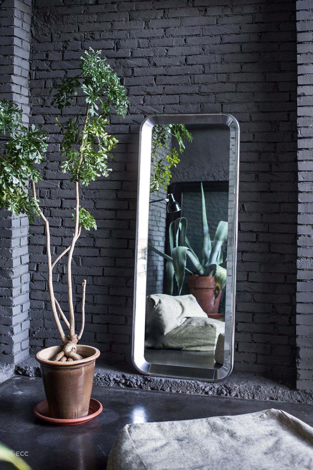 The Deja-vu Mirror by Magis, resting in the corner of a stylish space.