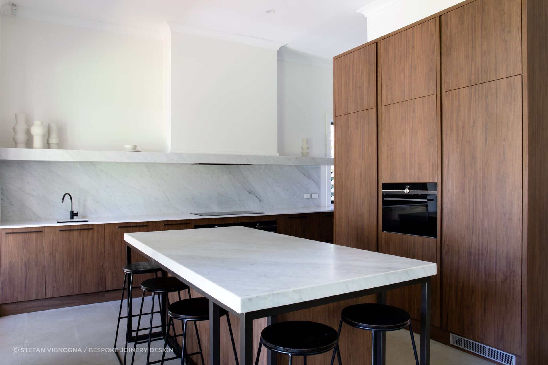 The walnut wood cabinetry of this impressive kitchen in Dulwich is a real feature of natural texture and warmth.