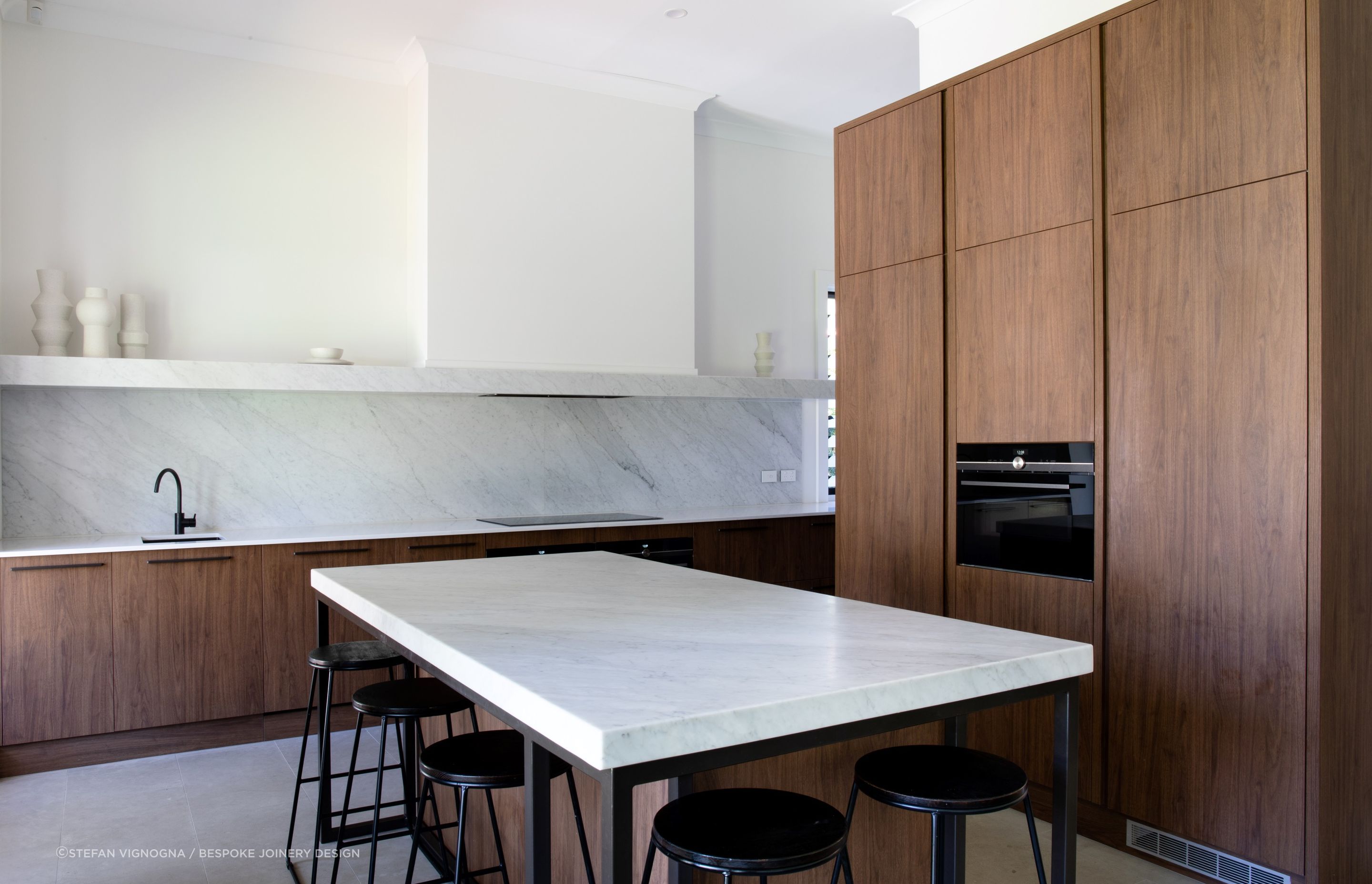 The walnut wood cabinetry of this impressive kitchen in Dulwich is a real feature of natural texture and warmth.