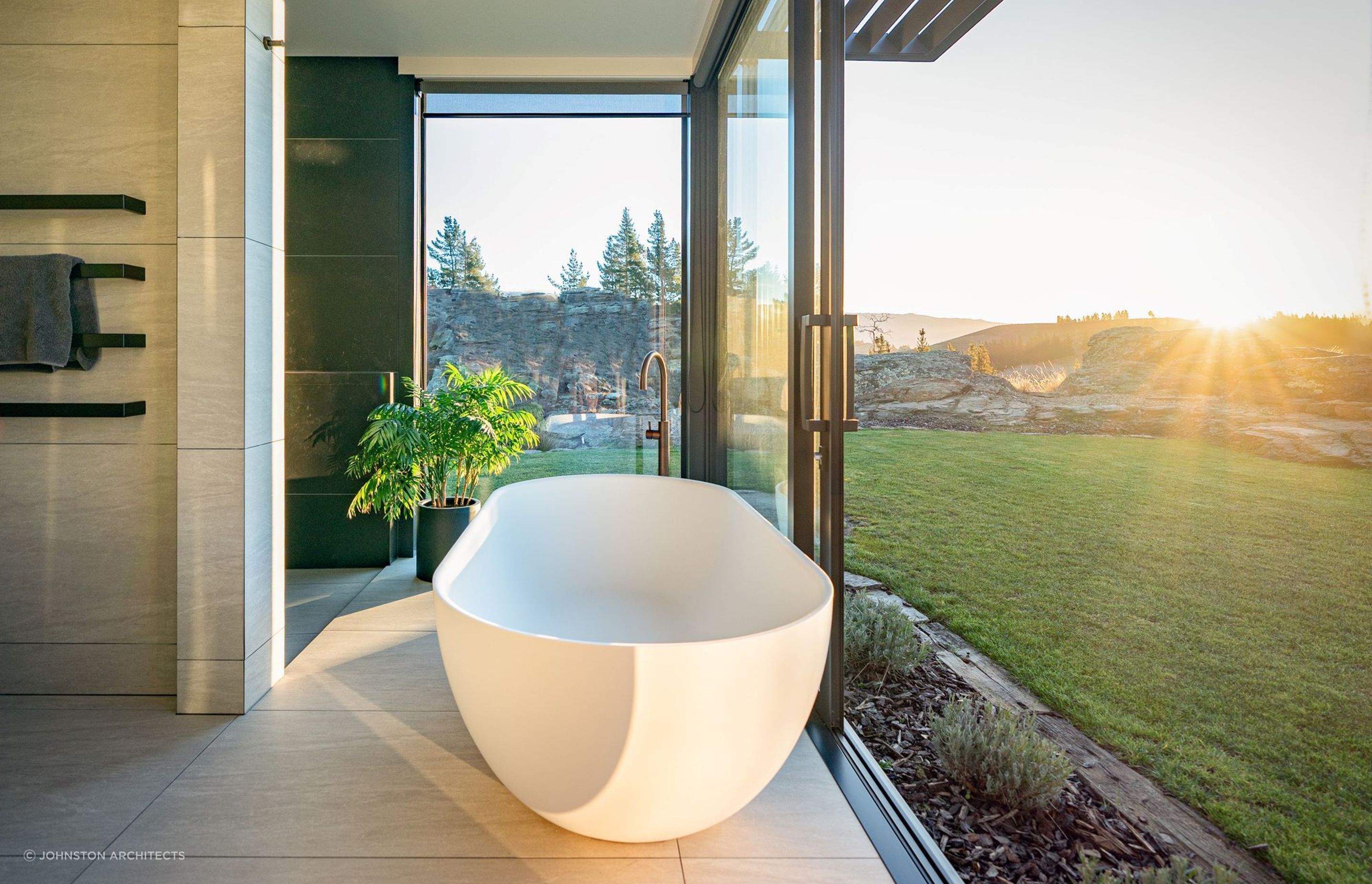 Sliding doors allow the crisp alpine air to breeze through the exquisite bathroom of the Earnscleugh Ridge Retreat — Photography: Larkin Photography