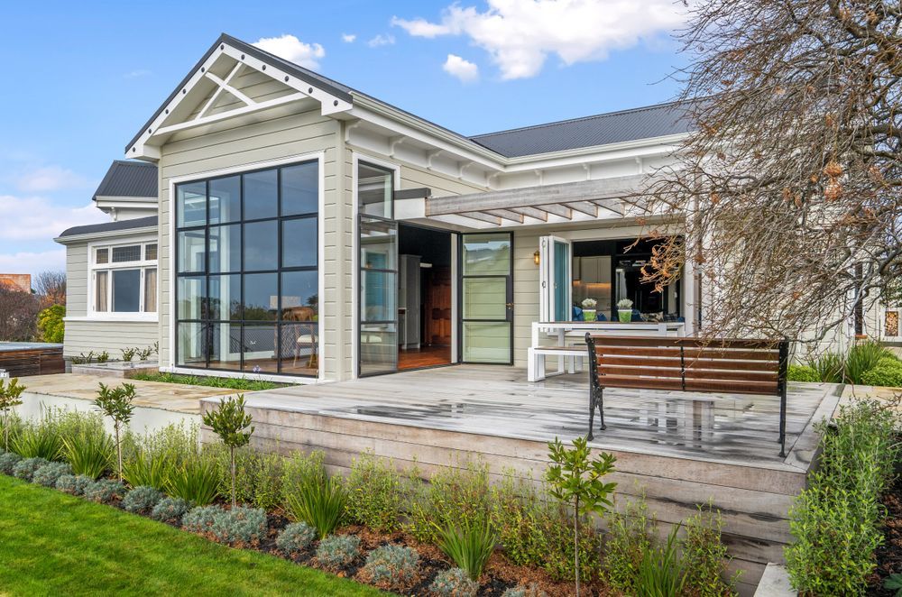 Steel windows enhance the architectural integrity of the home and provide an abundance of natural light that pours into the dining area inside.