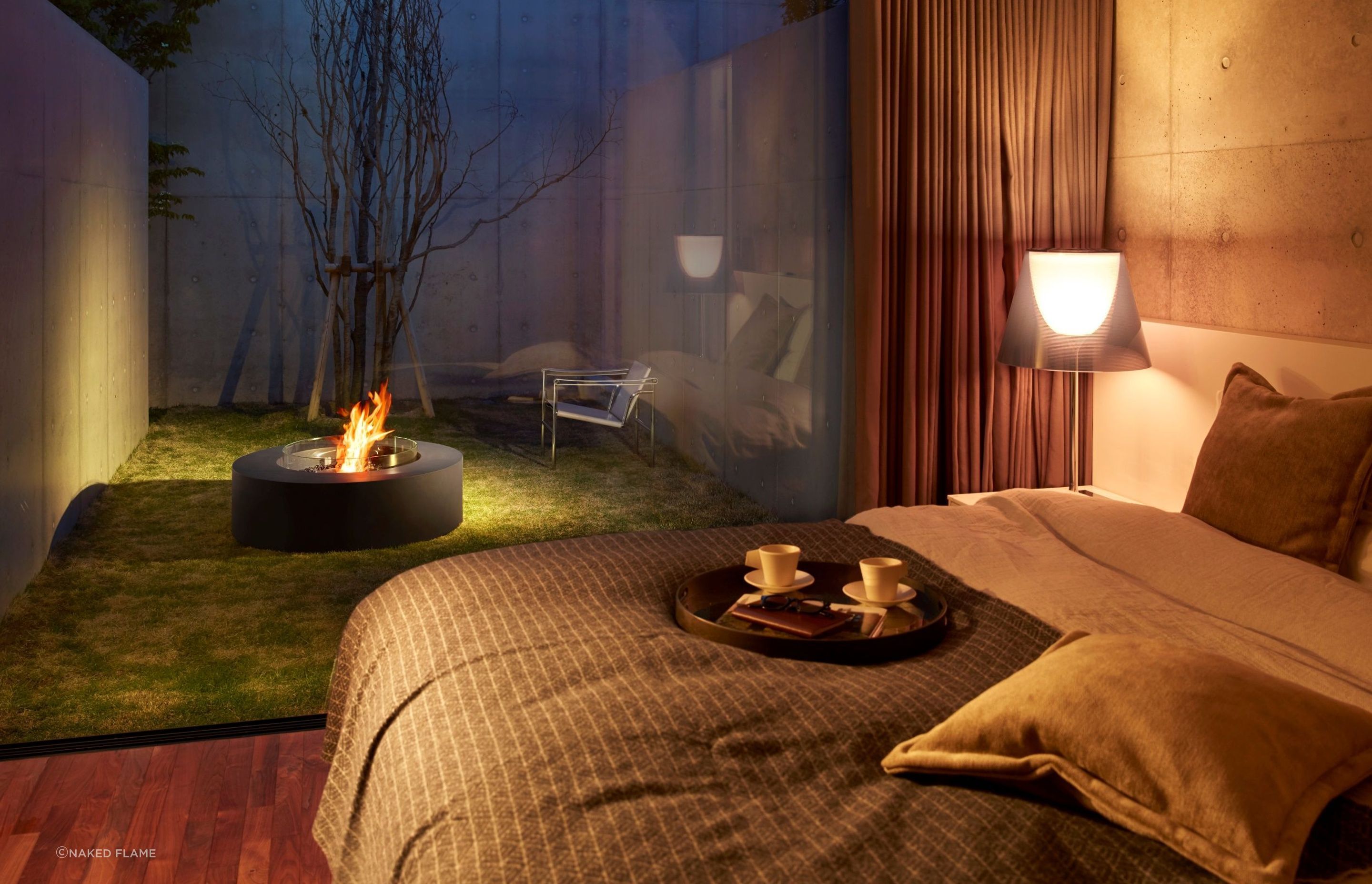 A fire pit can be enjoyed from inside the house as well as out, seen here with the EcoSmart Ark Fire Pit Table.