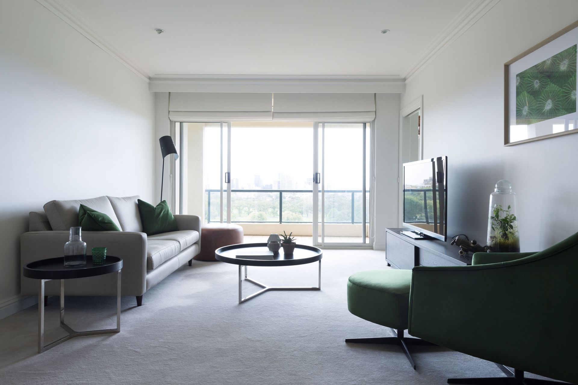 Deep green sofa cushions and various house plants provide this minimalist living space with a nice natural element. Featured project: Melbourne Apartment.