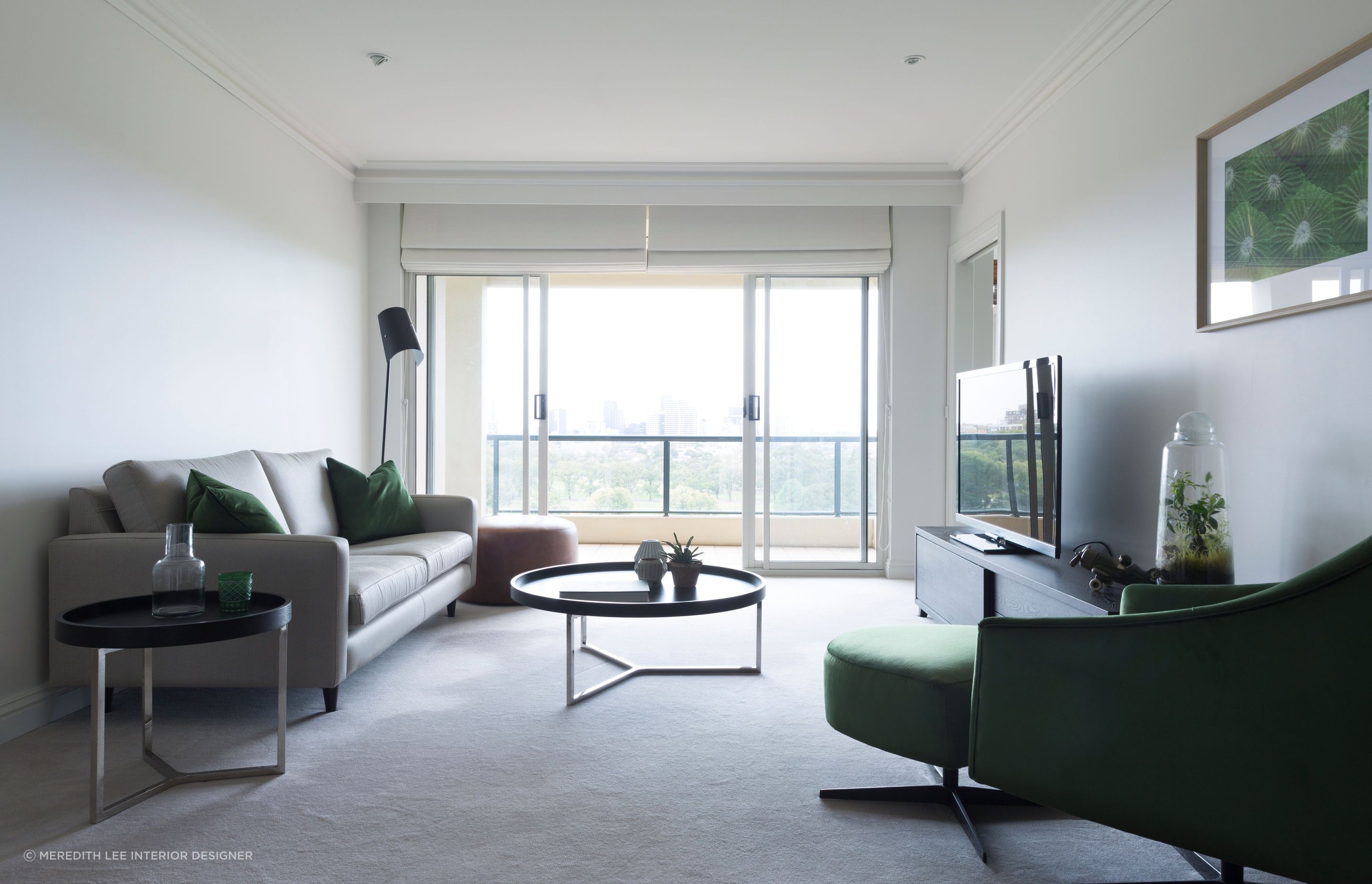 Deep green sofa cushions and various house plants provide this minimalist living space with a nice natural element. Featured project: Melbourne Apartment.