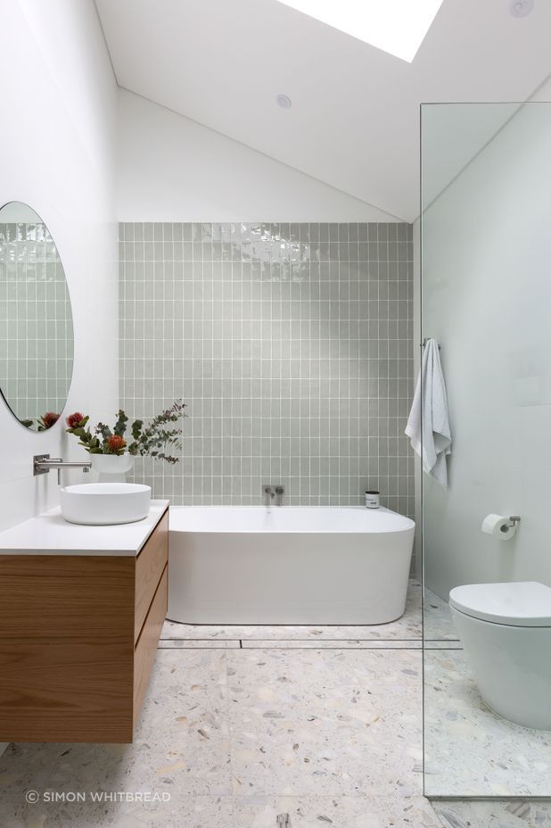 This bathroom by ViewThru Architects and Christina Prescott Design features a cathedral ceiling.