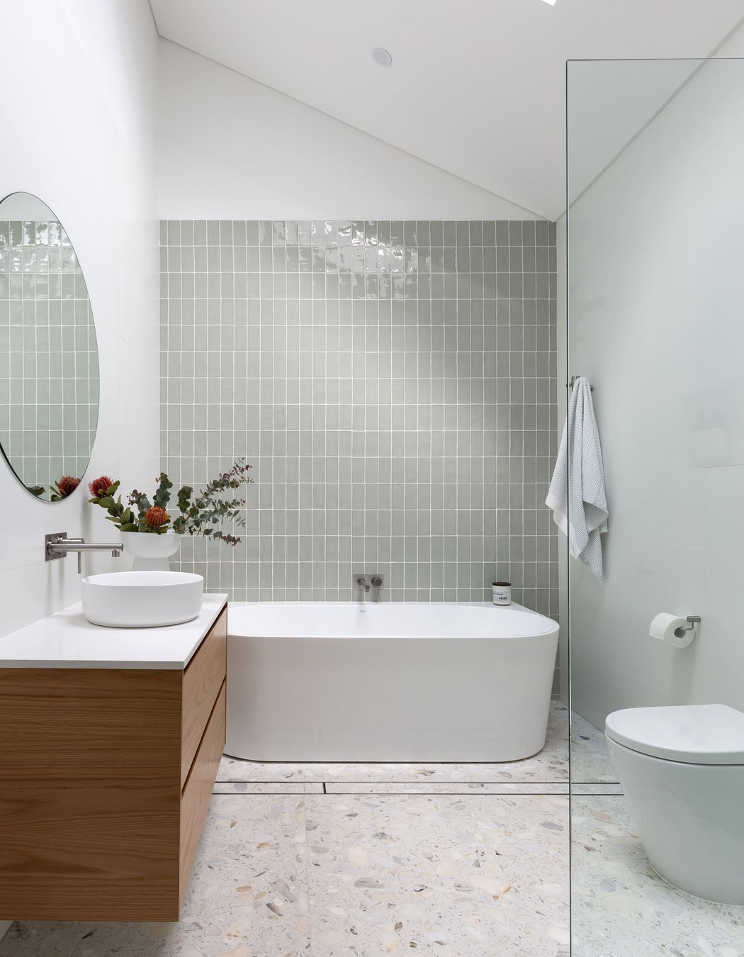 This bathroom by ViewThru Architects and Christina Prescott Design features a cathedral ceiling.