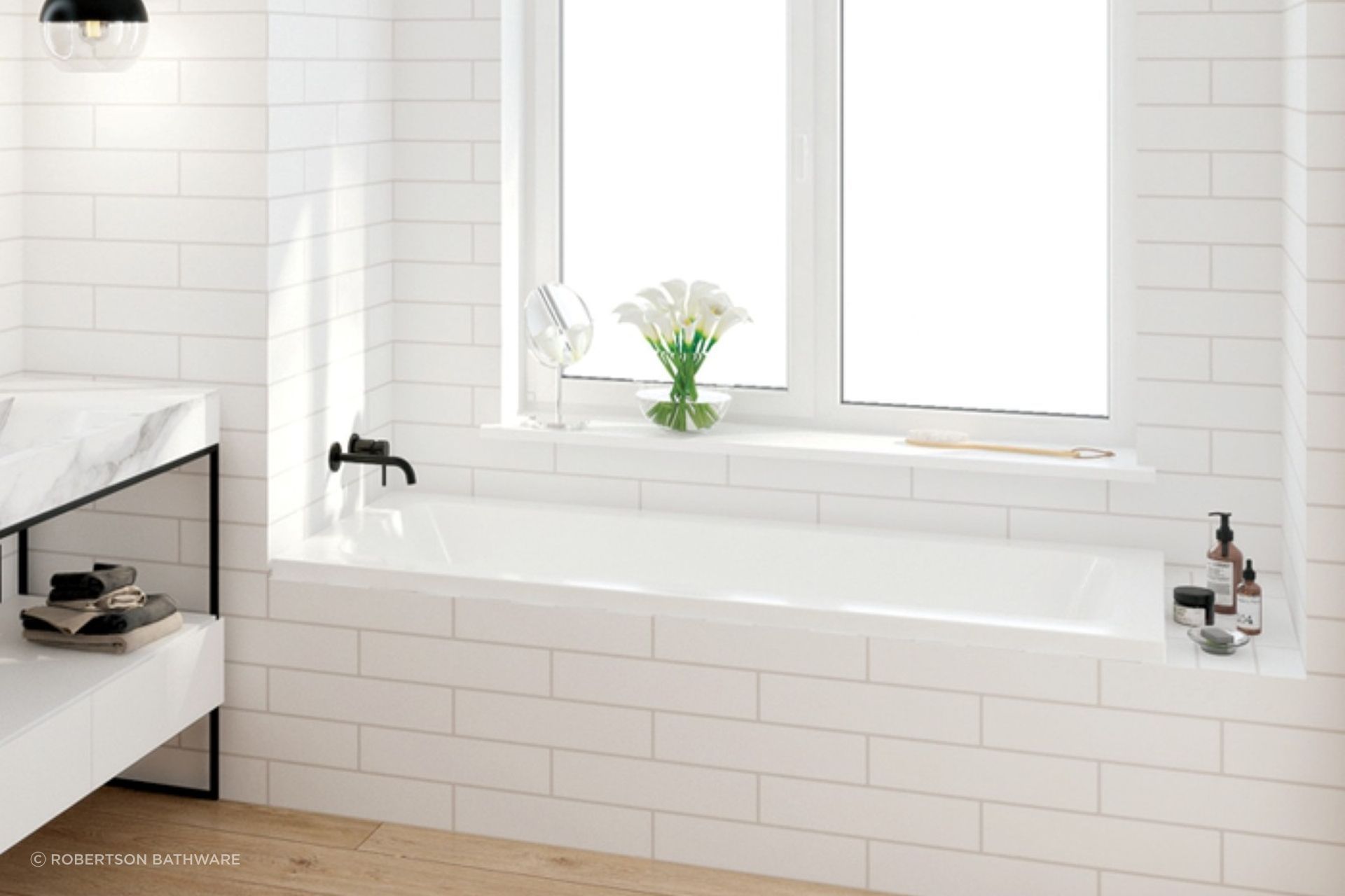A sleek drop-in bath from the Elementi Collection by Robertson Bathware, neatly installed in an alcove space.