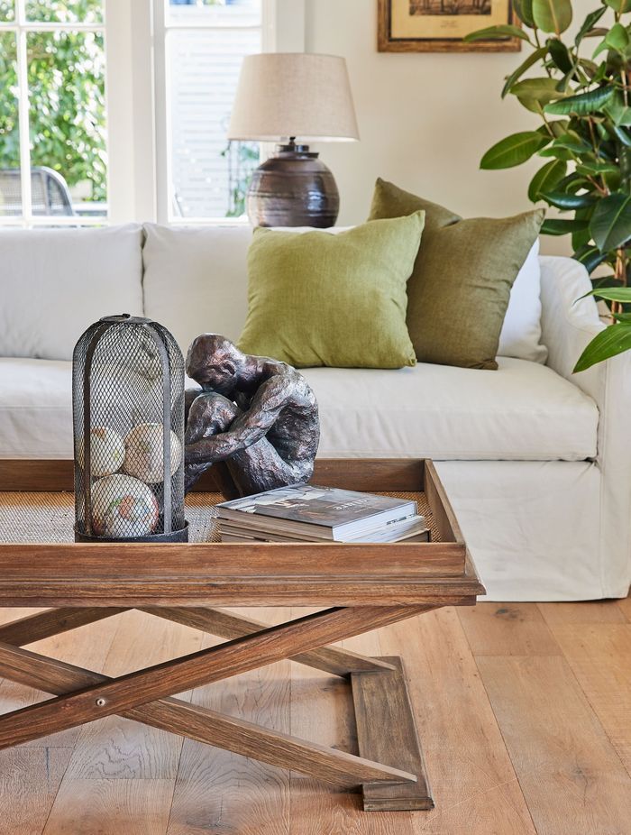 This coffee table's organic tones perfectly complement the room's interior style. Featured product: Cross Leg Coffee Table.