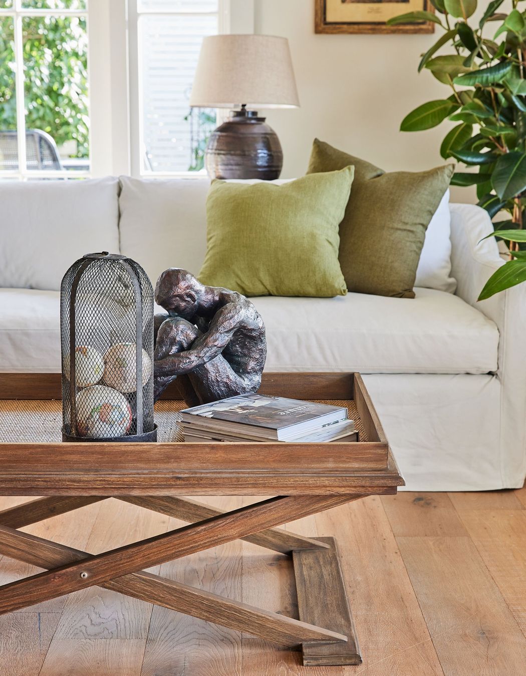 This coffee table's organic tones perfectly complement the room's interior style. Featured product: Cross Leg Coffee Table.
