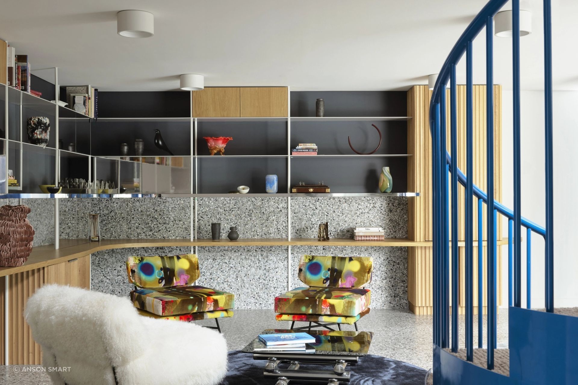 The stair's sculptural form is enhanced with a bright blue.