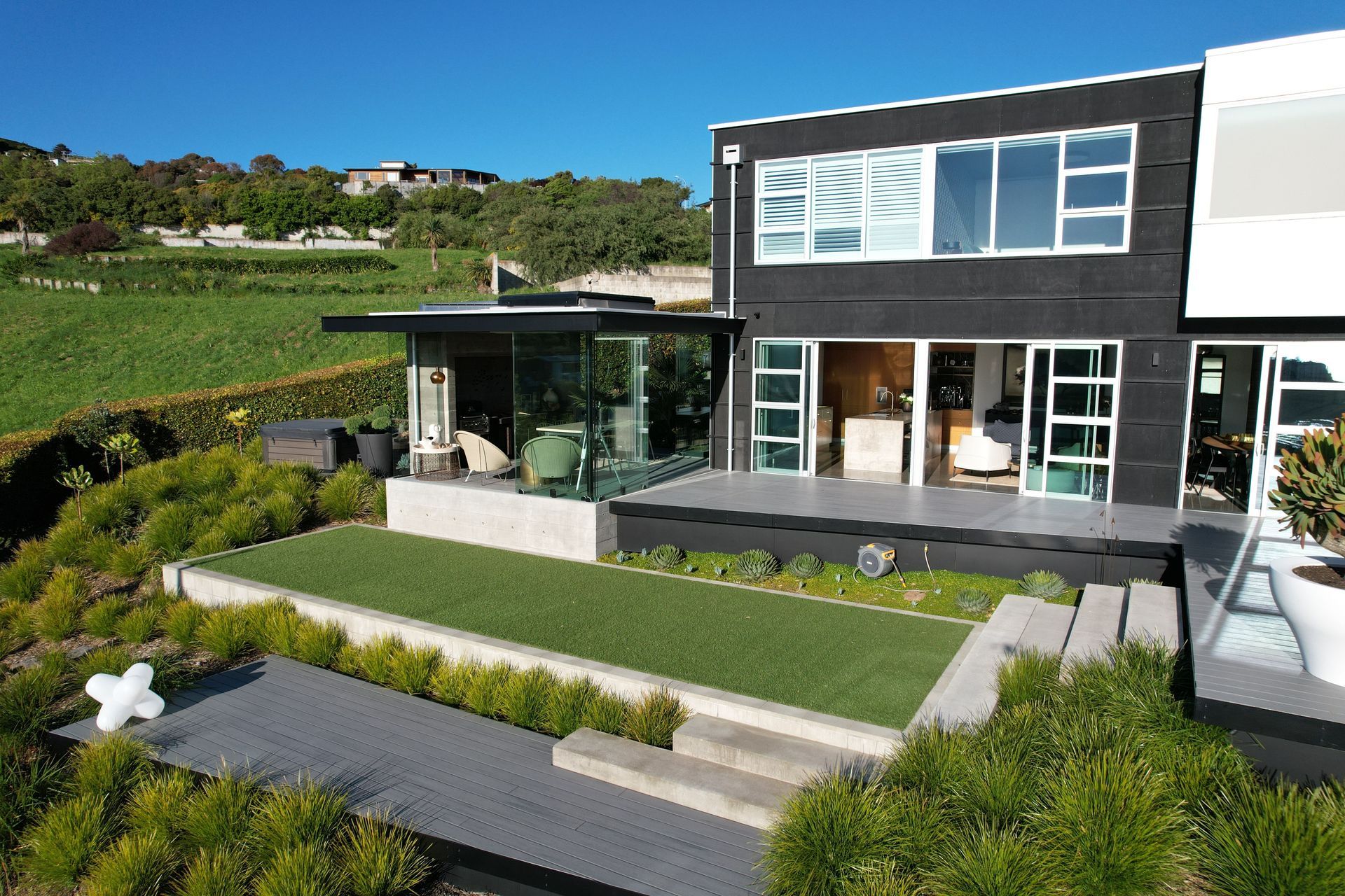 A combination of box forms and layered retaining allow this hillside home by DJ Hewitt Builders a beautiful rural view, whilst maximising the space for living.