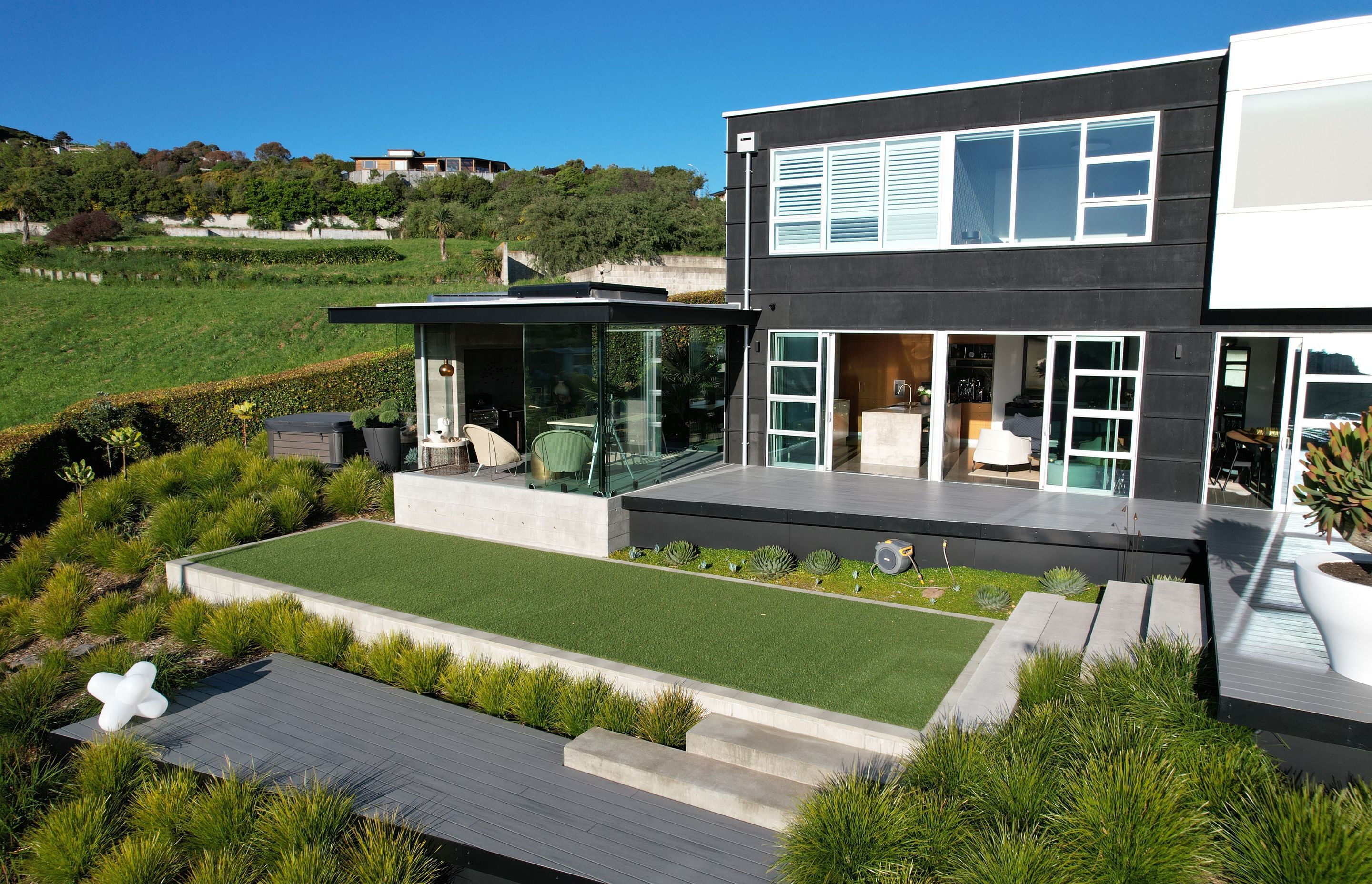 A combination of box forms and layered retaining allow this hillside home by DJ Hewitt Builders a beautiful rural view, whilst maximising the space for living.