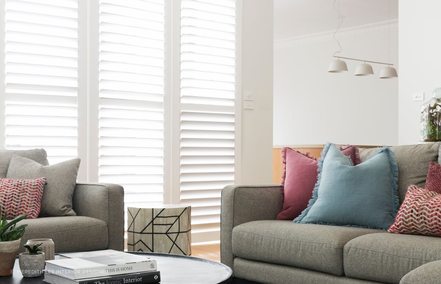 Red cushions can be infused with other bright tones for a sophisticated colour palette. Featured project: Ashburton House.