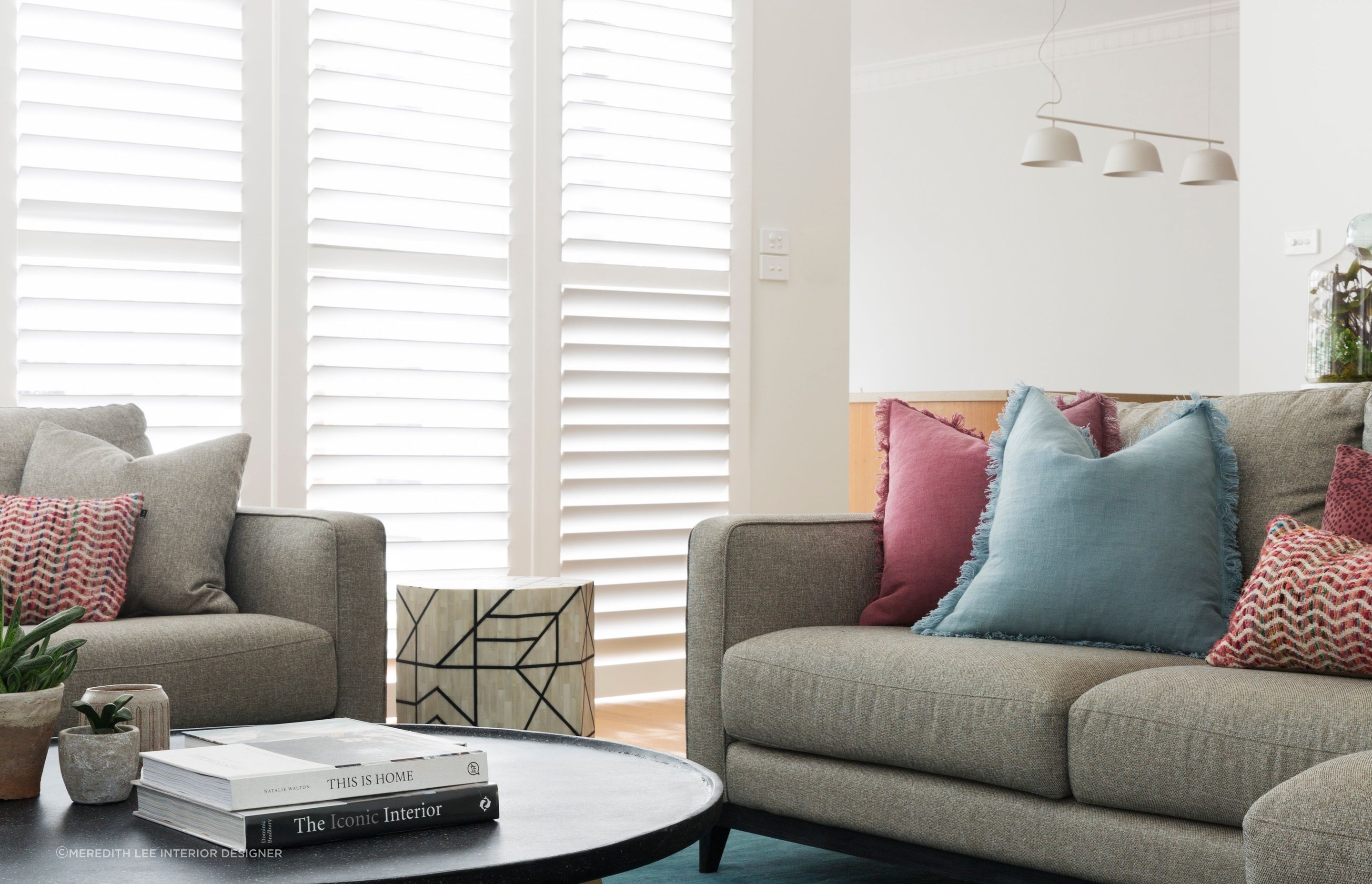 Red cushions can be infused with other bright tones for a sophisticated colour palette. Featured project: Ashburton House.