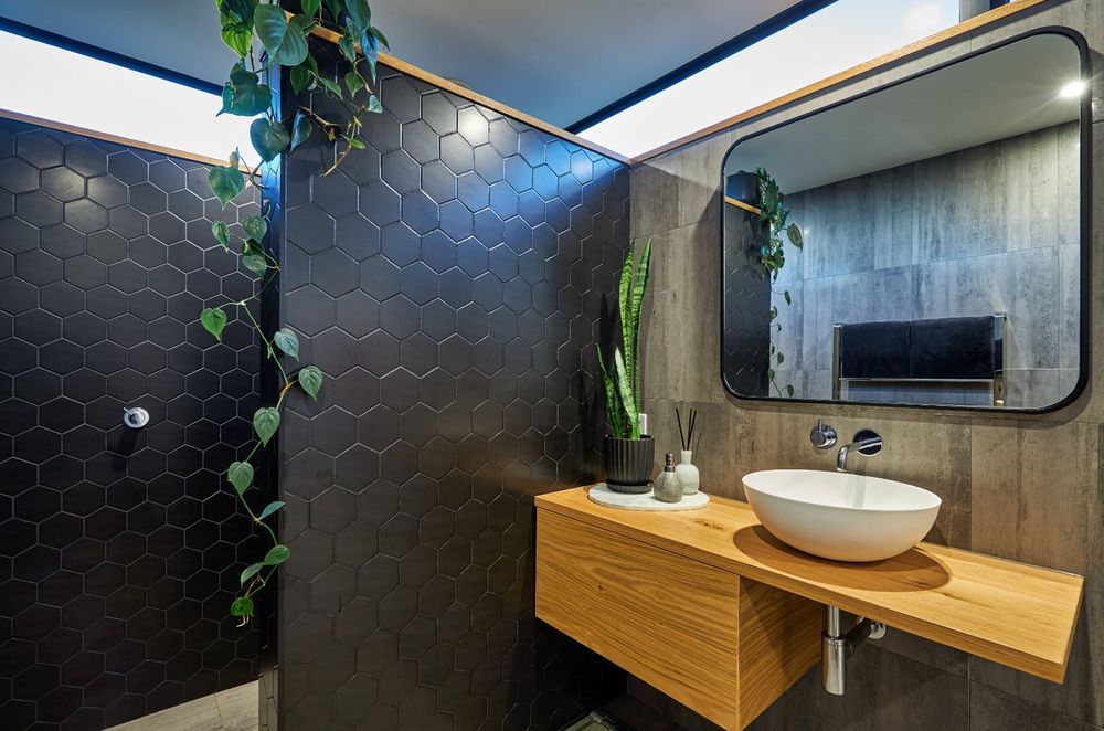 A strategically placed climbing plant and well poised pot plant are inviting additions to this Hapuku home bathroom — Photography: Andrew Spencer